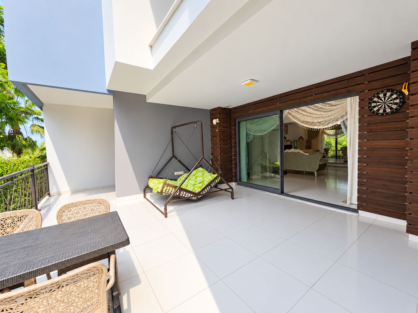 Terrace with a hanging swing, dartboard and an open passage to the living room in Kargicak, Türkiye