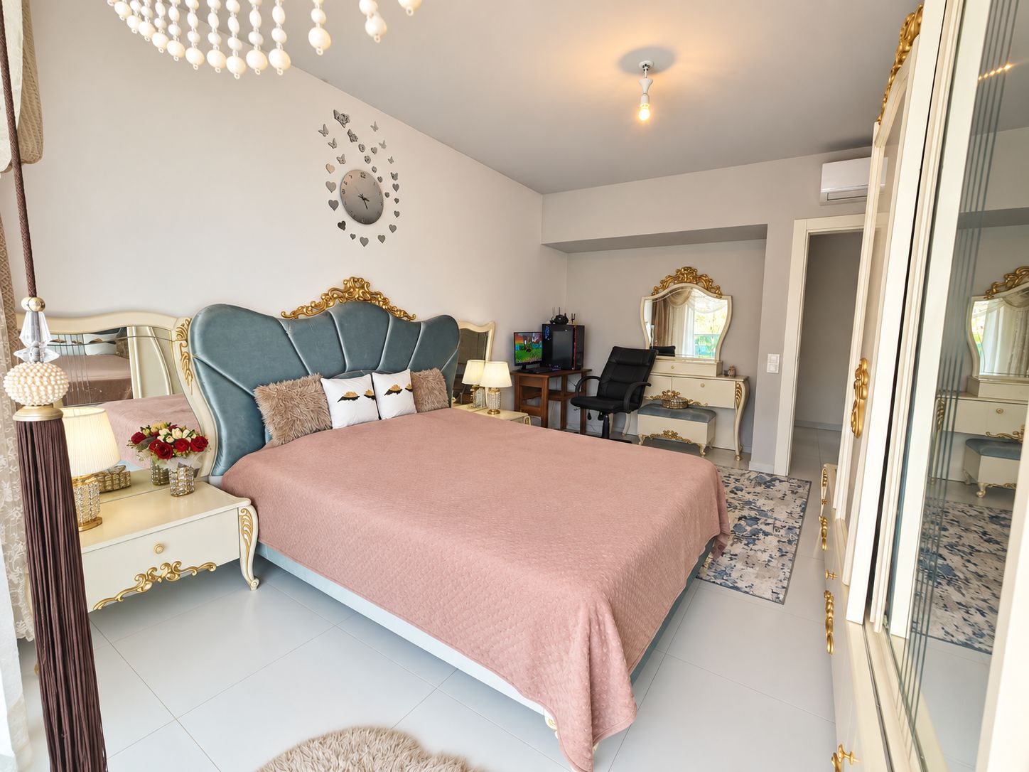 Bedroom with a pink-covered bed, vanity table and mirrored wardrobe in a 2+1 residence in Kargicak