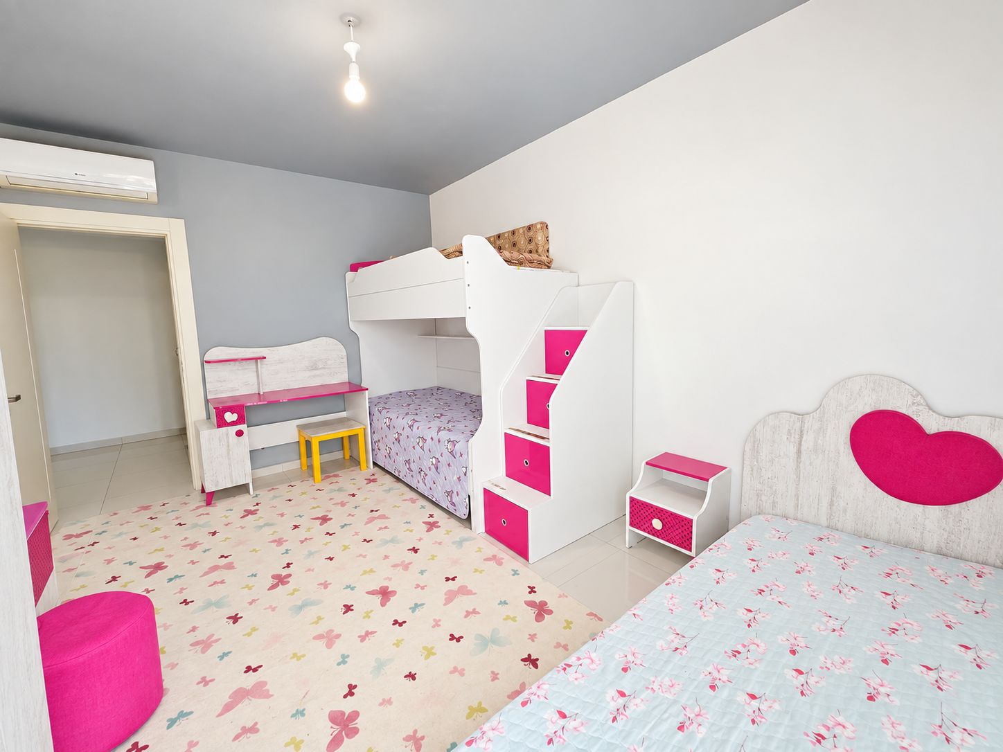 Children's bedroom with bunk bed, heart-shaped headboard and pink ottoman in an apartment in Kargicak