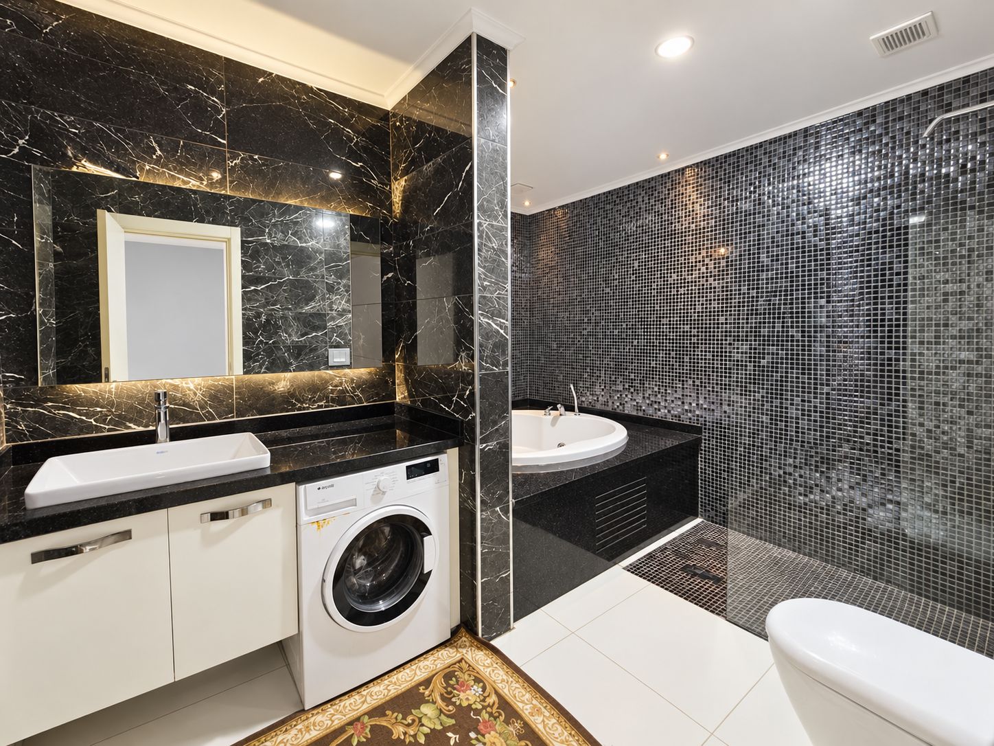Bathroom with a corner whirlpool tub, black mosaic shower and double vanity in an apartment in Kargicak
