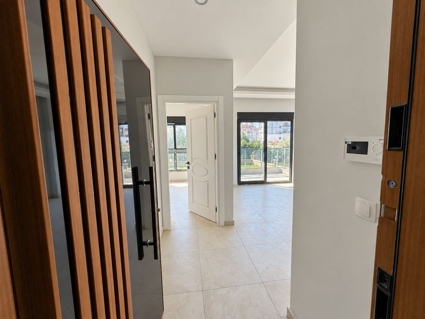 Entry hall with a slatted front door, video intercom and sliding balcony door in Demirtas