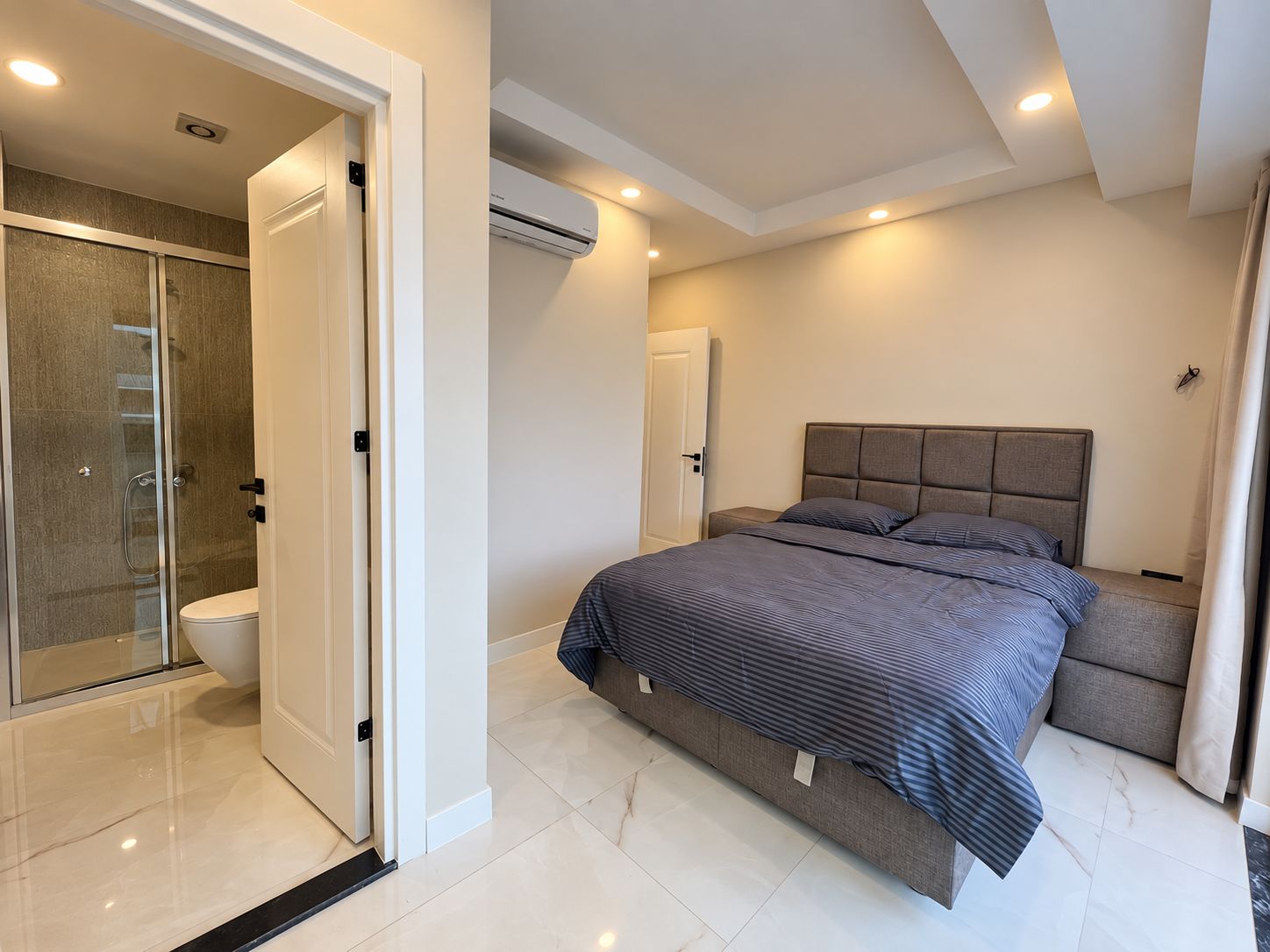 Yatak odasında Konaklı’daki 2+1 penthouse’a ait lacivert çizgili örtü ve spot ışıklı tavan