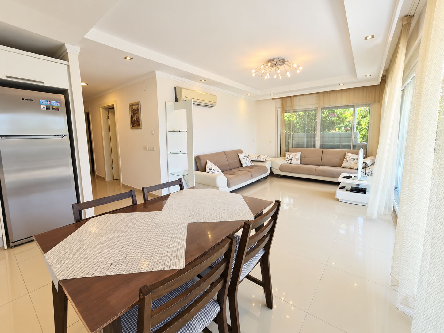 Bright kitchen-living room with two sofas and dark wood table in a residence in Türkiye