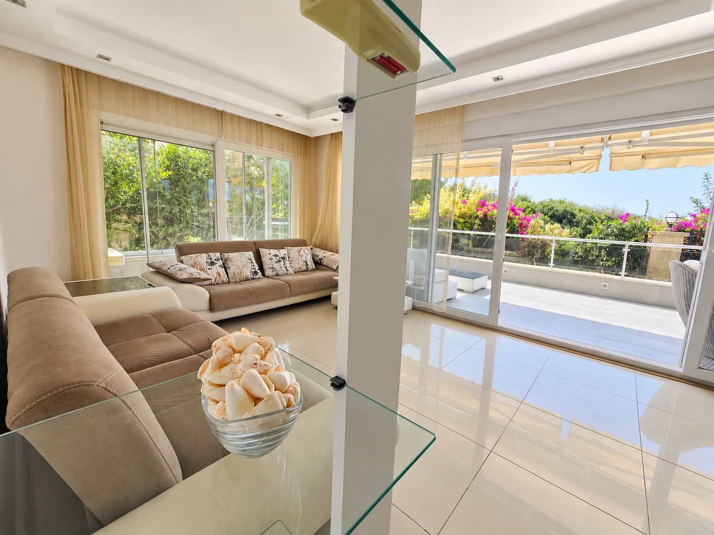 Living room with two beige sofas and terrace doors in an apartment in Konakli