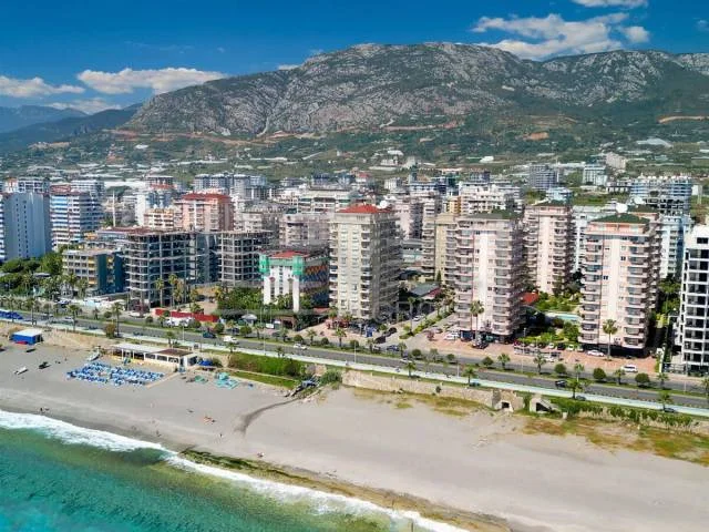 Пляж и высотная застройка у моря: квартира 2+1 в продаже в Махмутларе, Алания, Турция — New Level Group