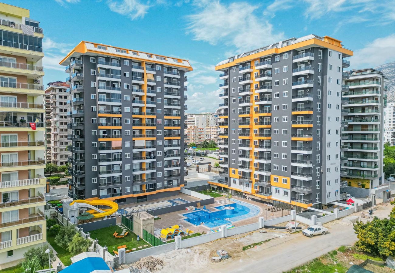 Вид сверху на бассейн между жилыми корпусами: квартира 2+1 в продаже в Махмутларе, Алания, Турция — New Level Group