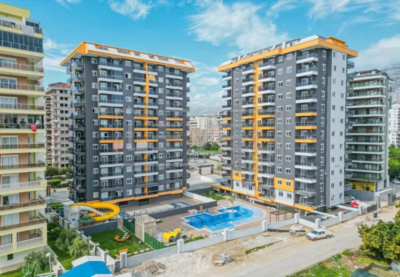 Вид сверху на бассейн между жилыми корпусами: квартира 2+1 в продаже в Махмутларе, Алания, Турция — New Level Group