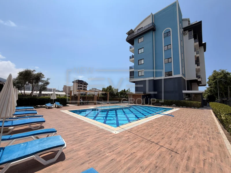 Mavi desenli açık havuz ve şezlonglar, Kargıcak'ta Türkiye'deki daireli sitede