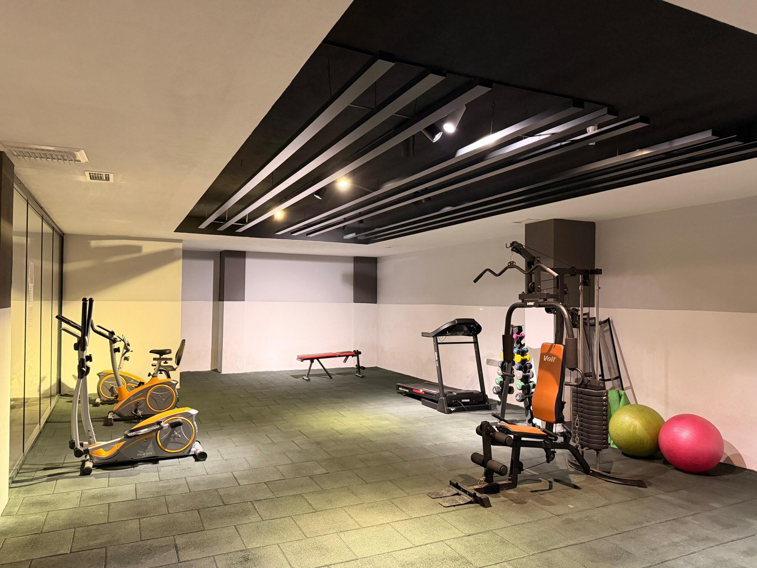 Spor salonunda koşu bandı, kondisyon bisikletleri ve dambıl rafı