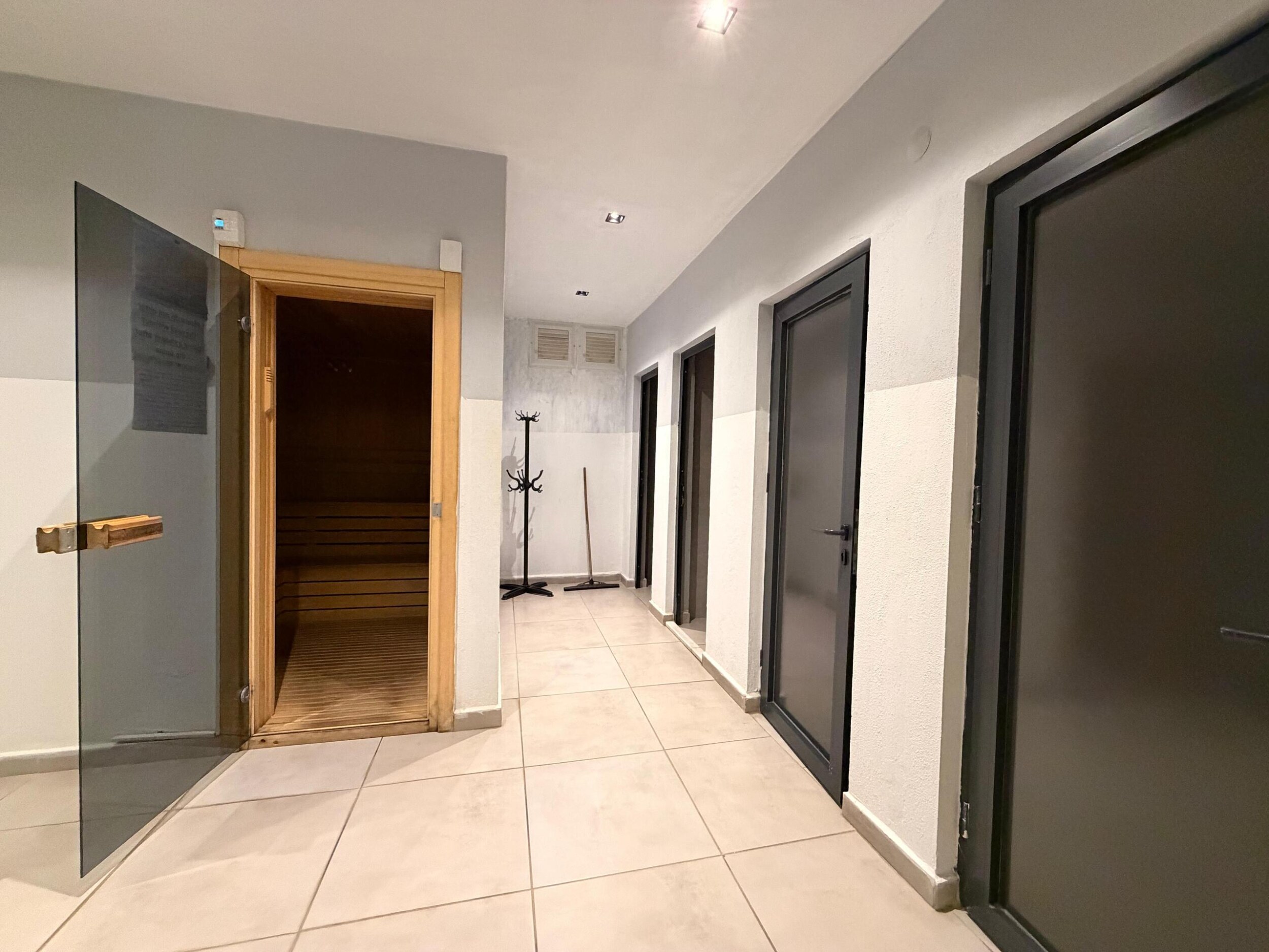 Daireli sitenin koridorunda koyu renk kapılar ve sauna girişi