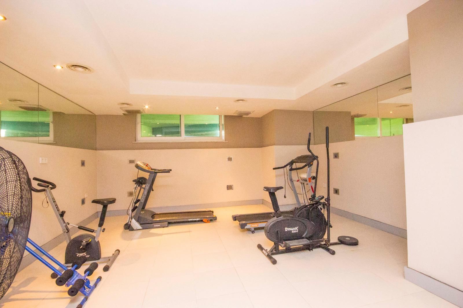 Spor salonunda eliptik bisiklet, koşu bandı ve boydan boya ayna, rezidans sakinleri için