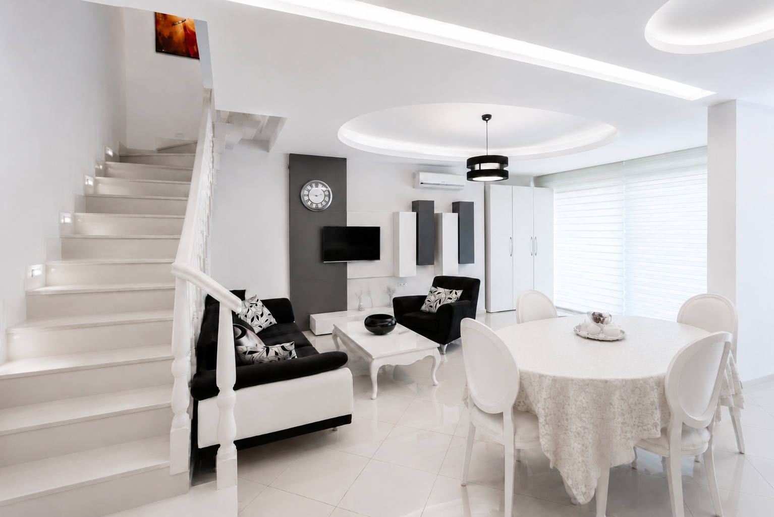 Mutfaklı salonda beyaz merdiven, oval masa ve siyah beyaz kanepe, Türkiye’nin Oba bölgesindeki 3+1 penthouse’da