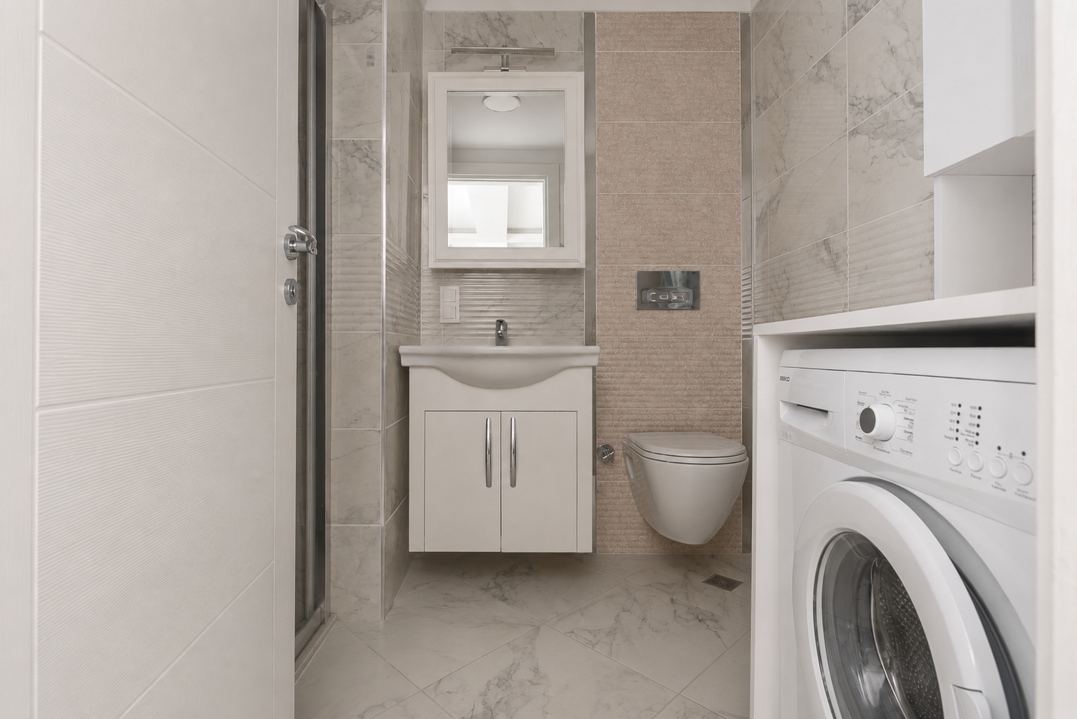 Gömme nişte çamaşır makinesi, cam duş kabini ve mermer görünümlü duvar fayanslı banyo