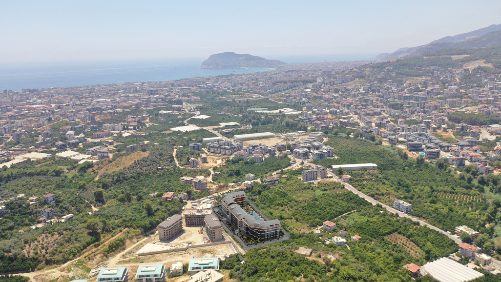 Deniz kıyısı ve dağlık burunla uzanan yeşil panorama, Türkiye’de satılık dairelerin çevresinde