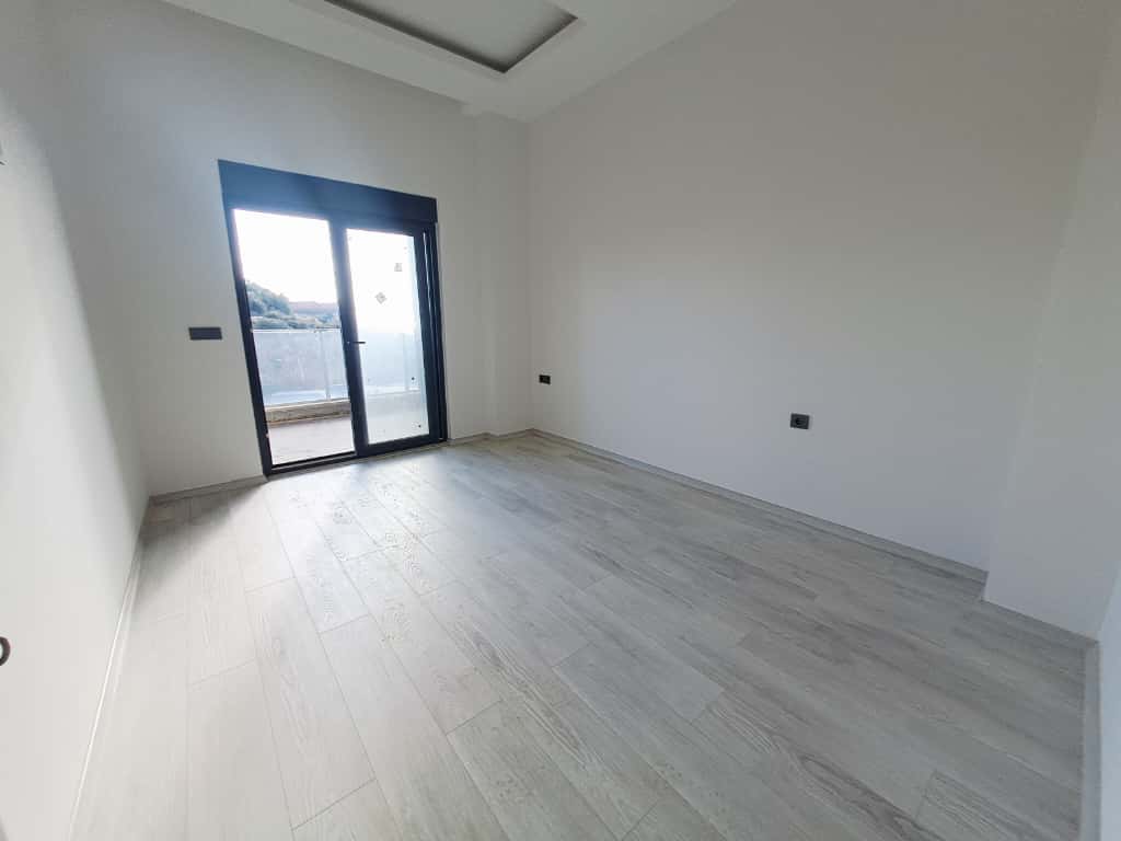 Спальня в квартире 1+1 в Каргыджаке с раздвижной дверью и выходом на балкон