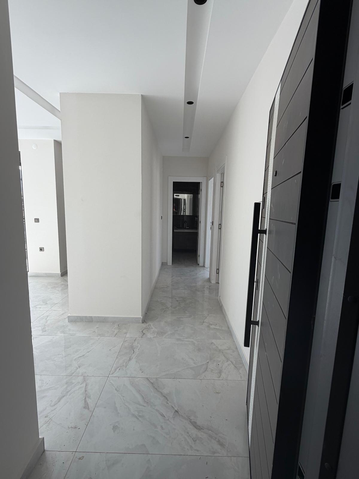 Long bright hallway with marble flooring and spotlights inside an apartment in Alanya