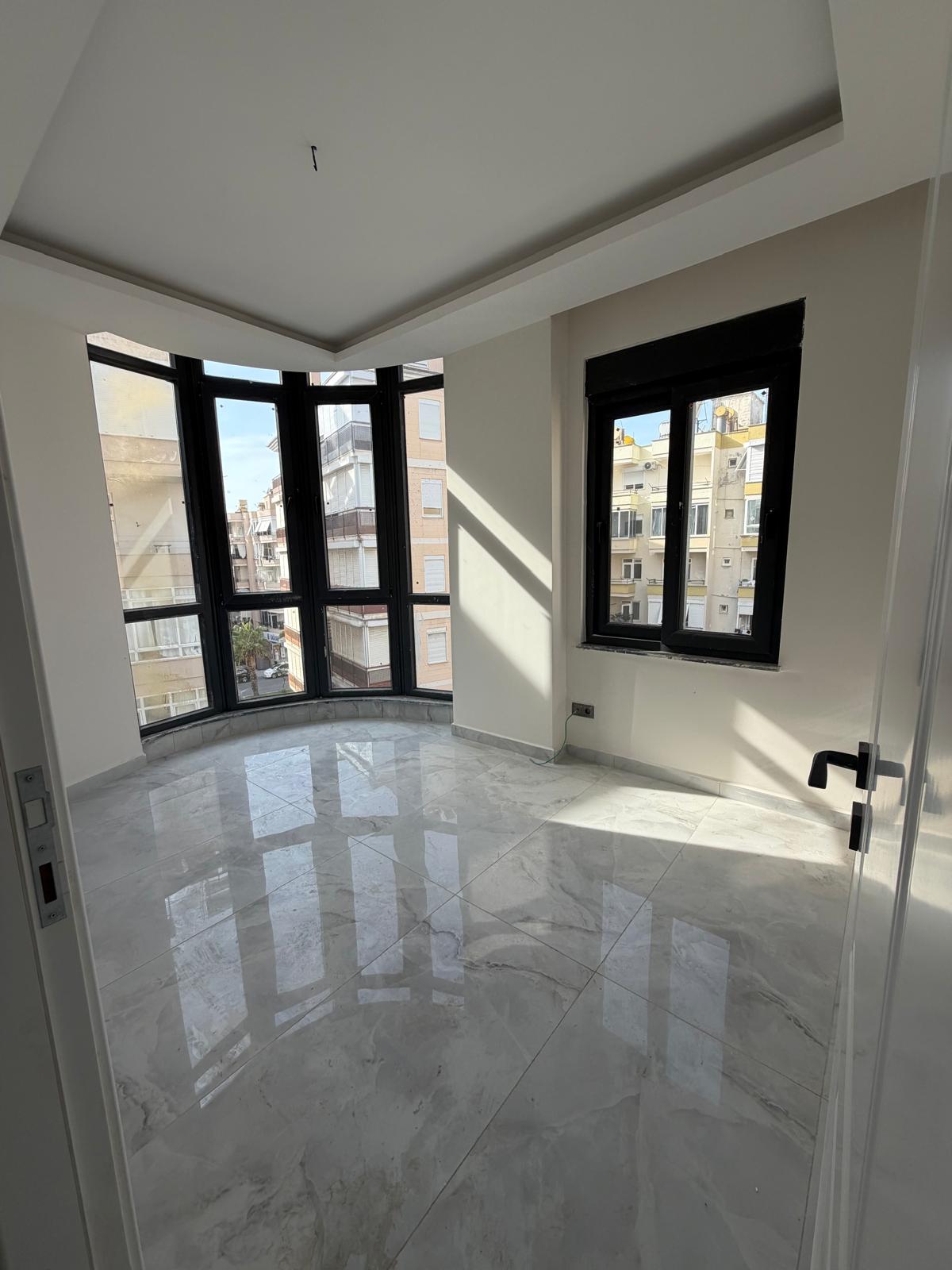Bright bedroom with corner panoramic glazing and a glossy marble floor in a residence
