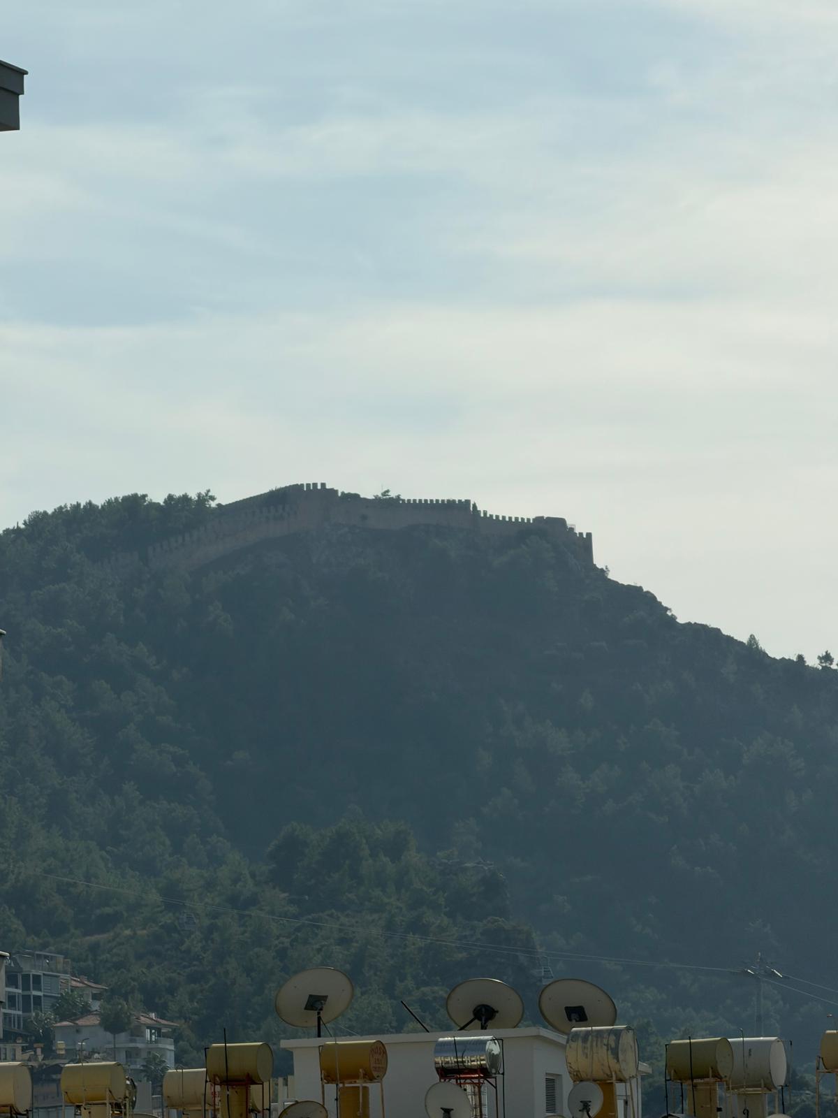 Mountain view with a hilltop fortress and solar water heaters from an apartment in Alanya