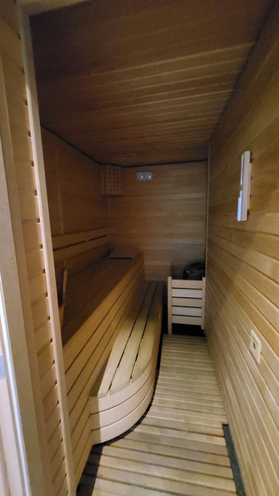 Сауна с деревянными полками и каменкой в комплексе с апартаментами в Алании