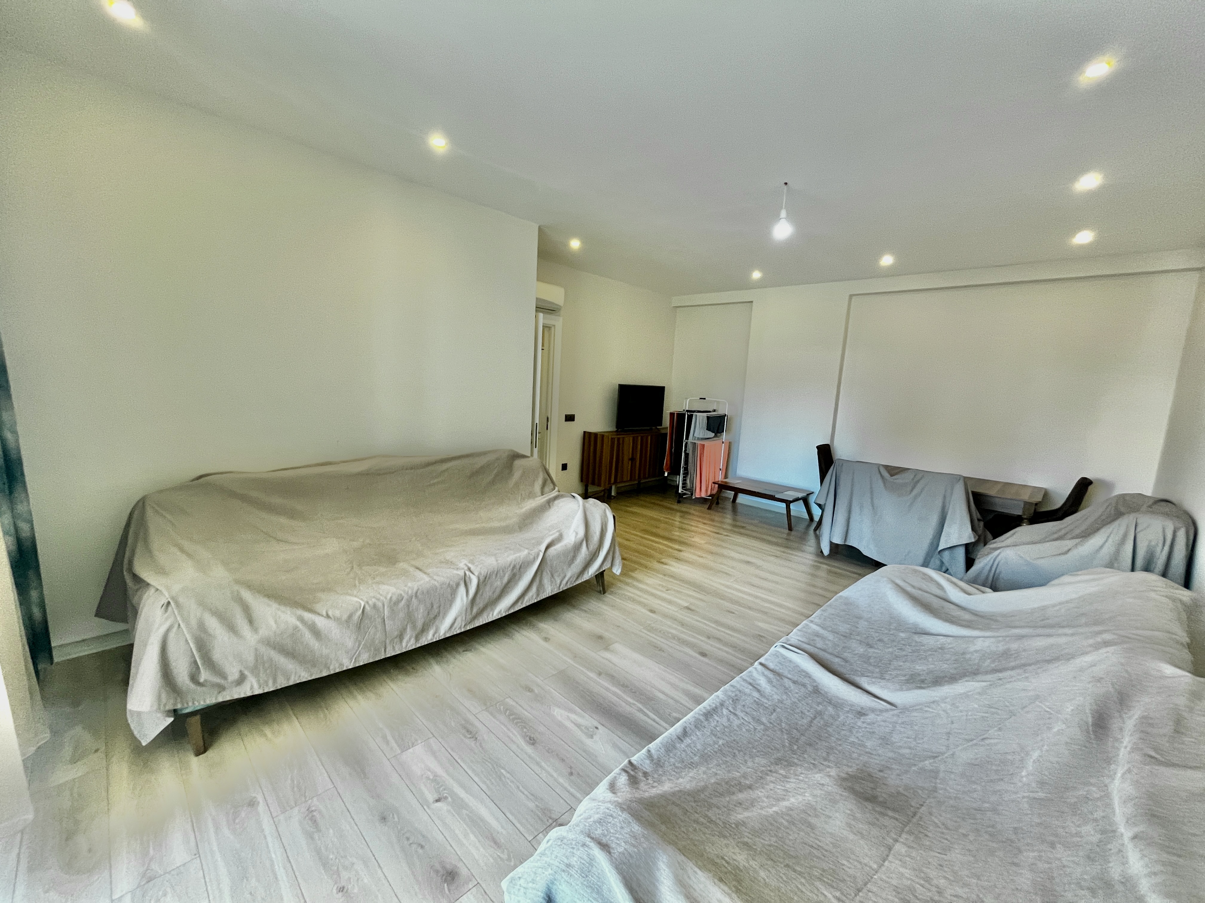 Living room with sofas, television and decorative panels in a flat for sale