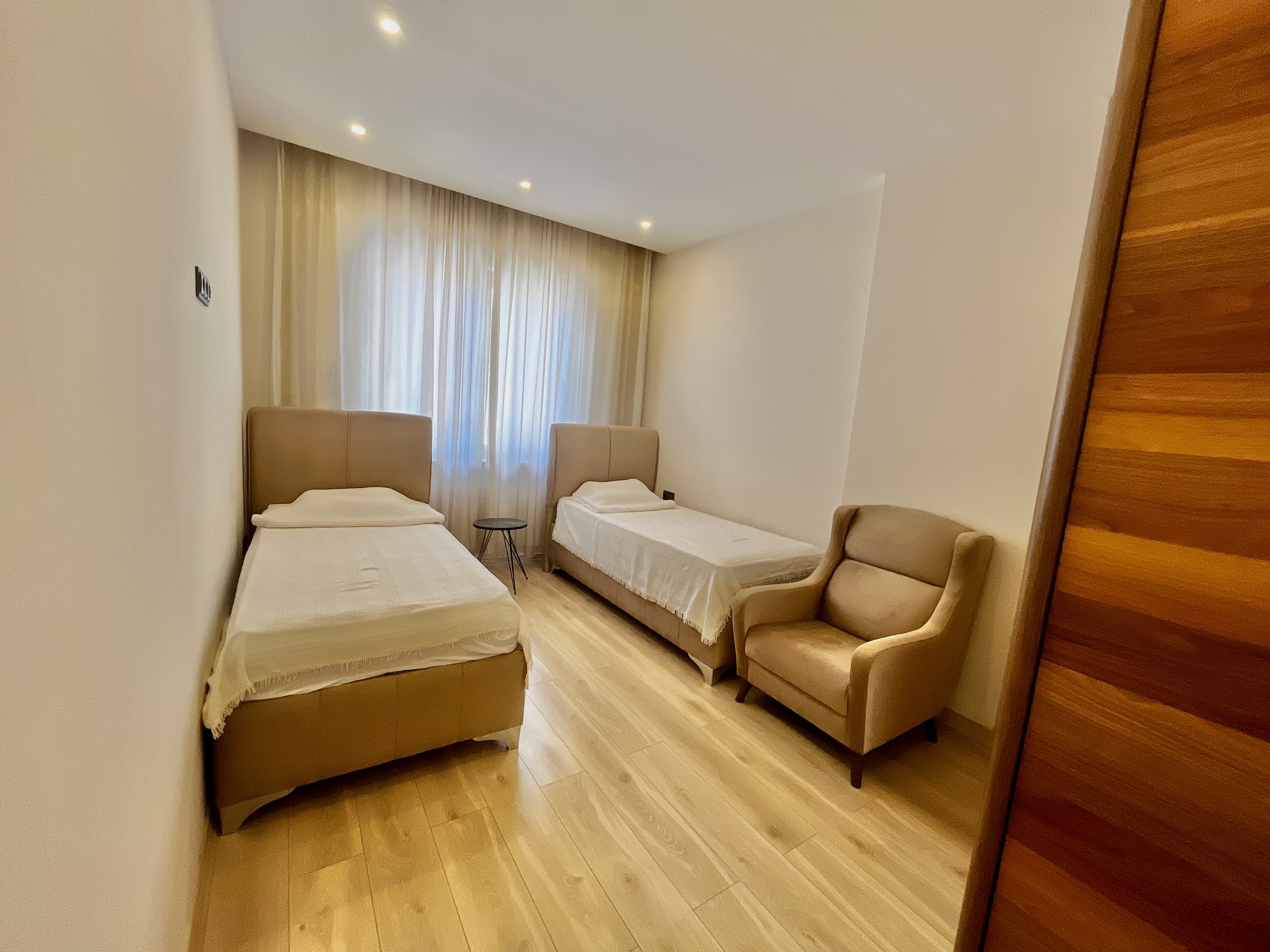 Bedroom with two single beds and panoramic window in an apartment in Alanya