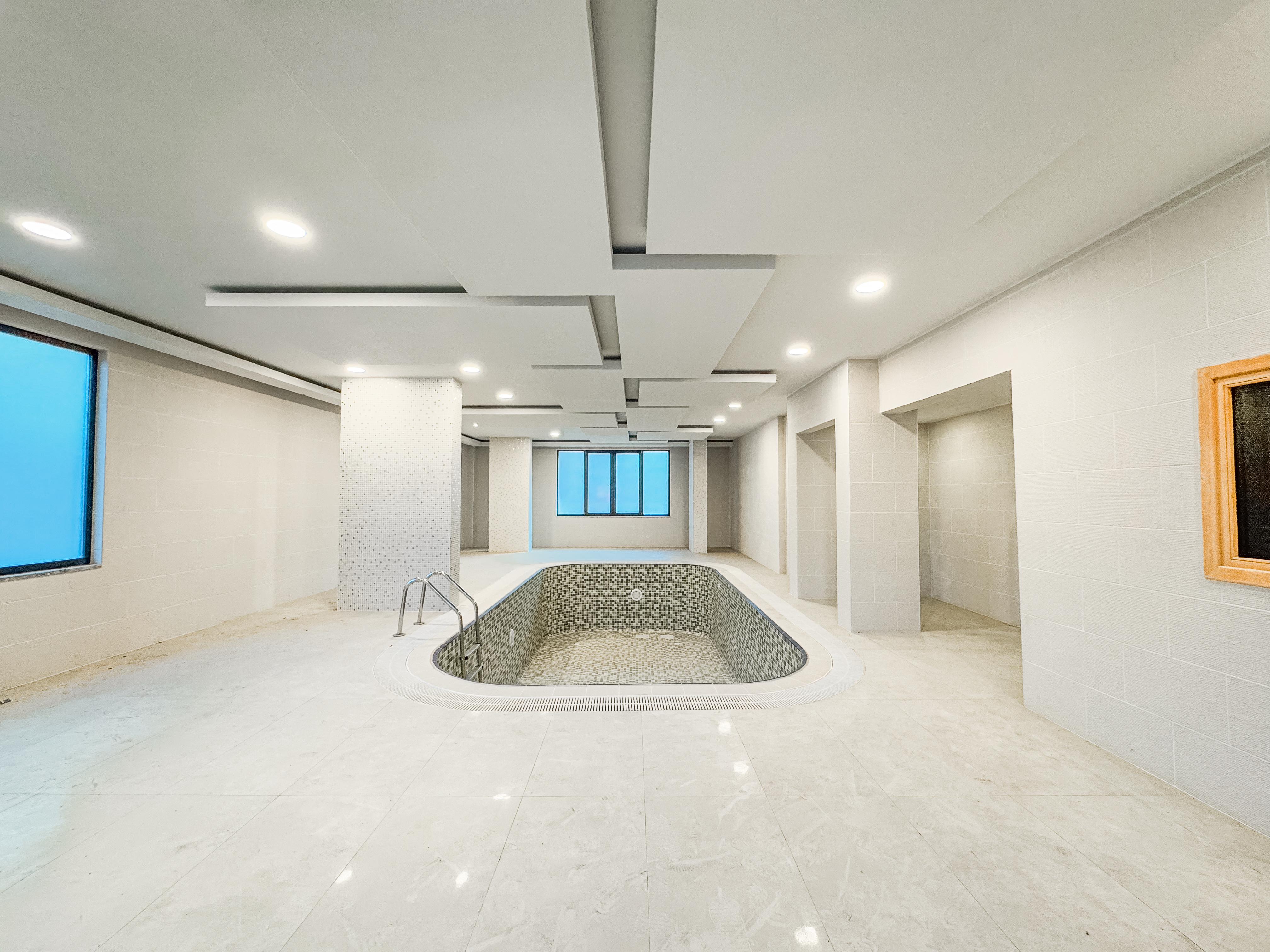 Indoor pool with mosaic basin, marble floor and panoramic windows in Turkey where apartments are for sale