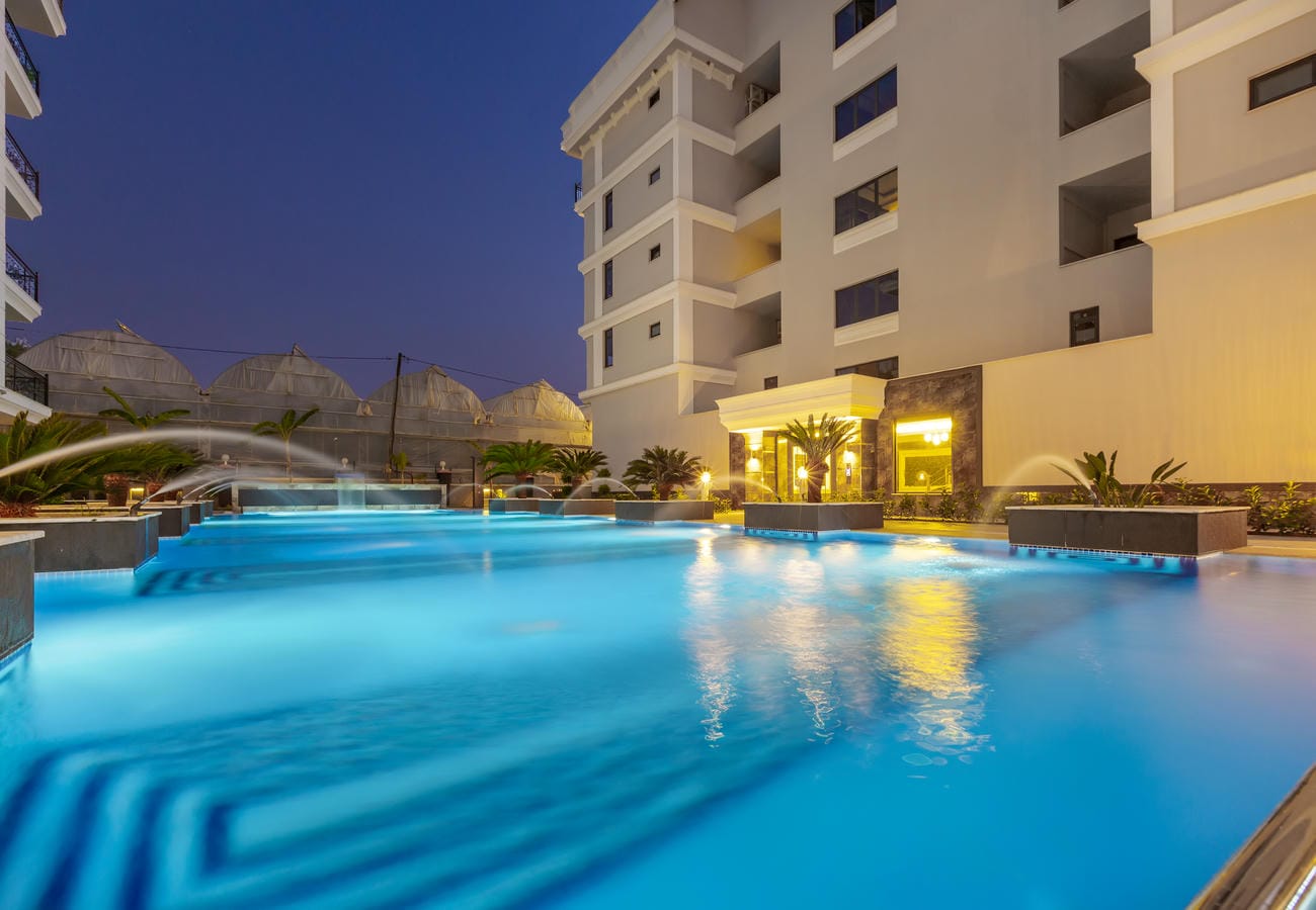 Alanya’da Türkiye’de daireli rezidans önünde kavisli su kemerleri olan gece havuzu