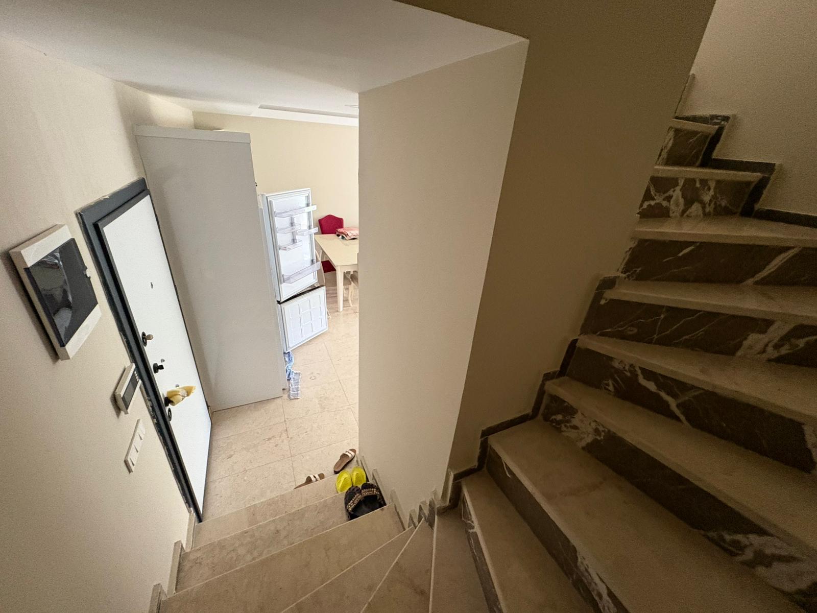 Koyu mermer merdivenli ve beyaz giriş kapılı antre, penthouse içinde