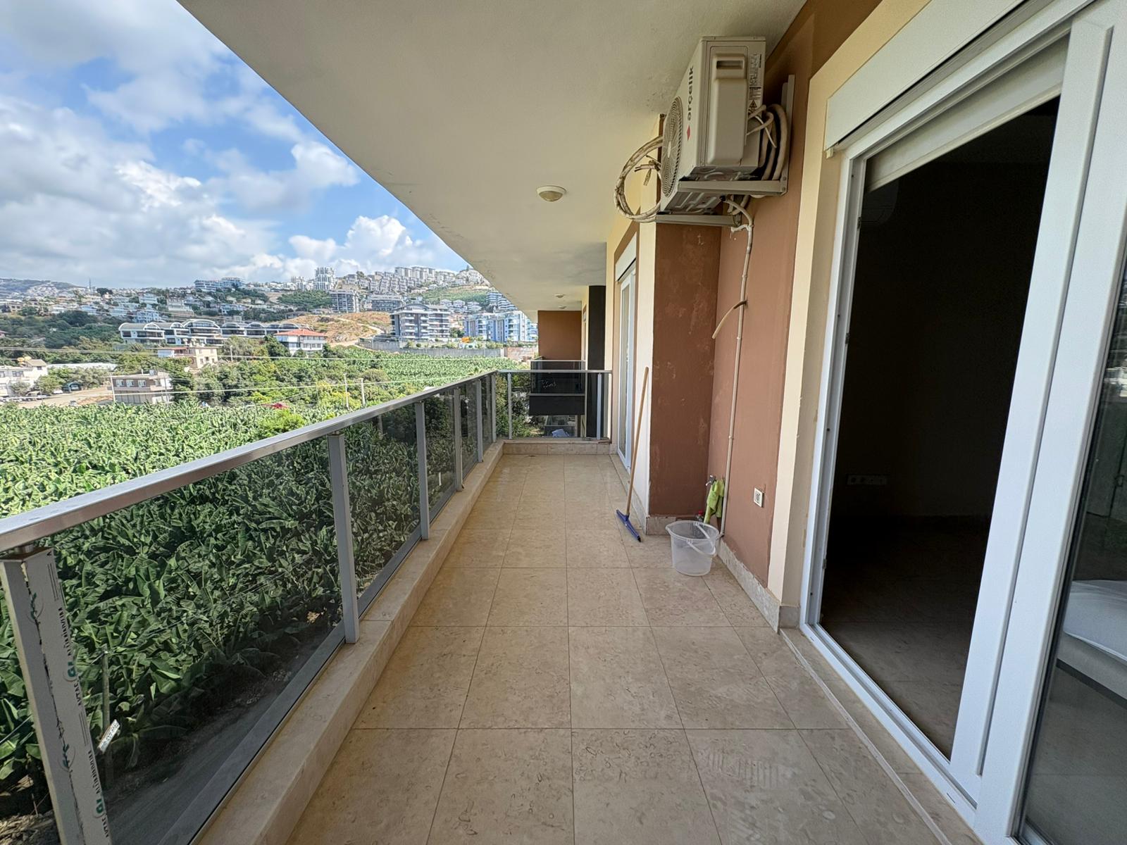 Bej döşemeli uzun balkondan muz bahçelerine bakış, Kargıcak’ta satılık penthouse yanında