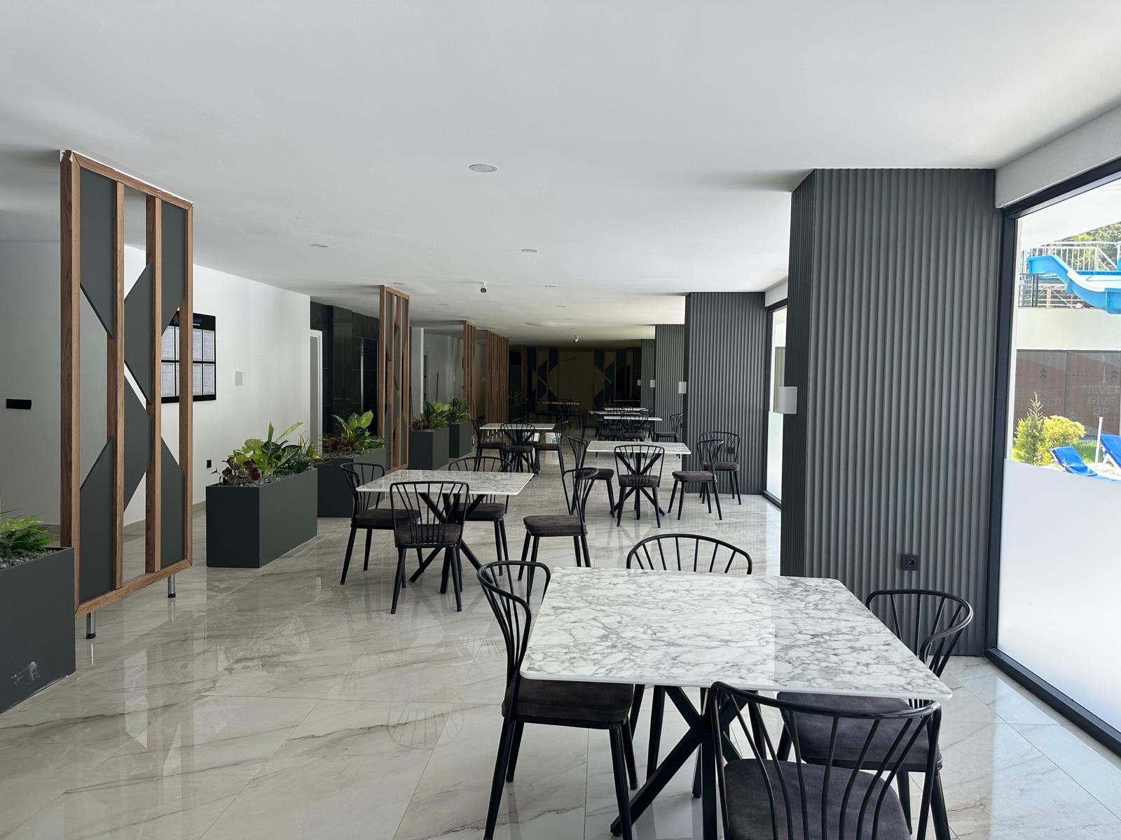 Mermer masalı kafe, Avsallar’da dairelerin bulunduğu sitede panoramik pencereler ve ahşap bölmelerle düzenlenmiş