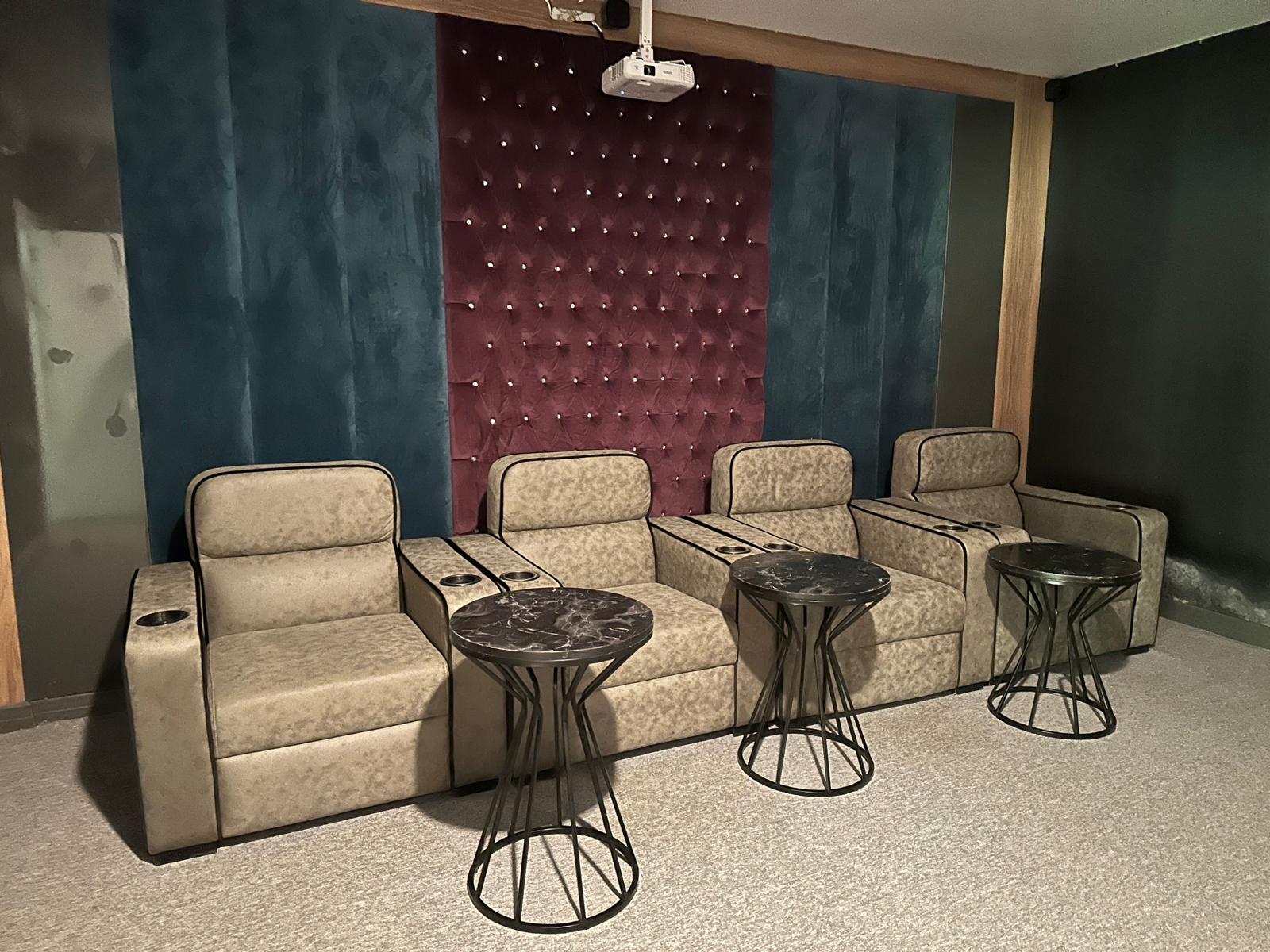 Sıralı yumuşak koltuklu sinema salonu, dairelerin bulunduğu sitede tavandaki projektörle birlikte