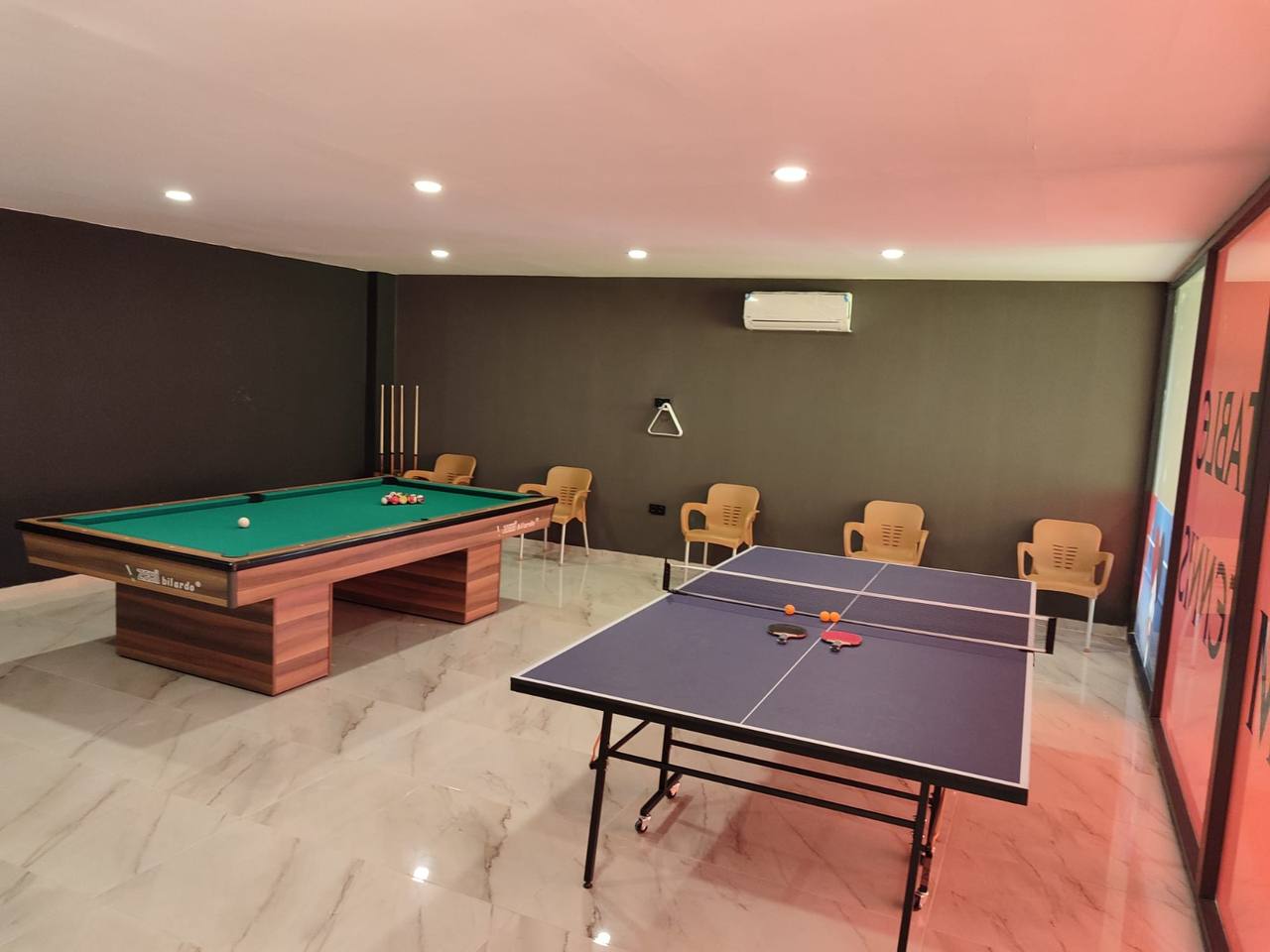 Bilardo ve tenis masalı salon, Avsallar’da dairelerin bulunduğu sitede akşam aydınlatması altında