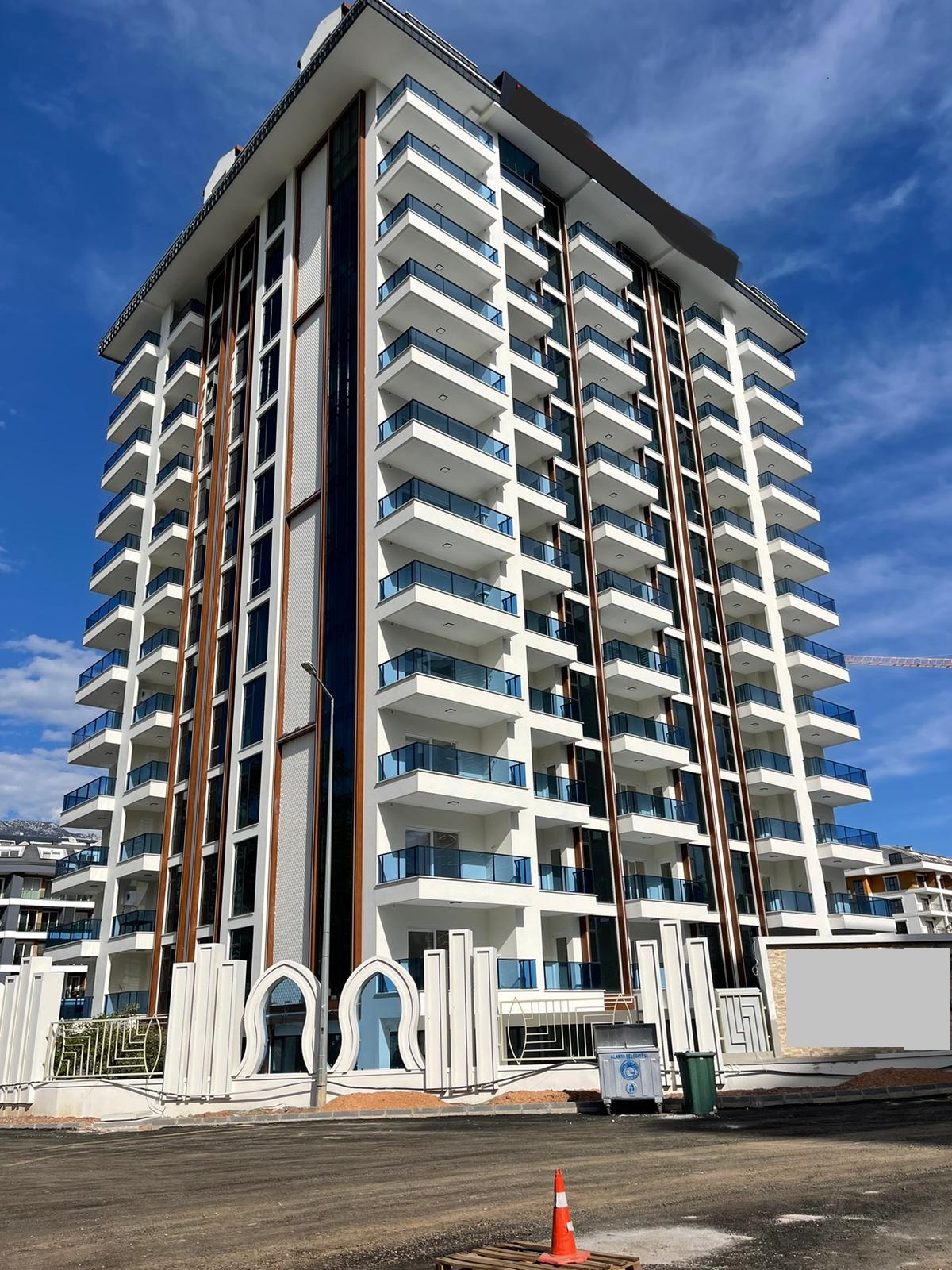 Panoramik camlı beyaz cepheli yapı: Mahmutlar’da satılık 1+1 daire, Türkiye — New Level Group