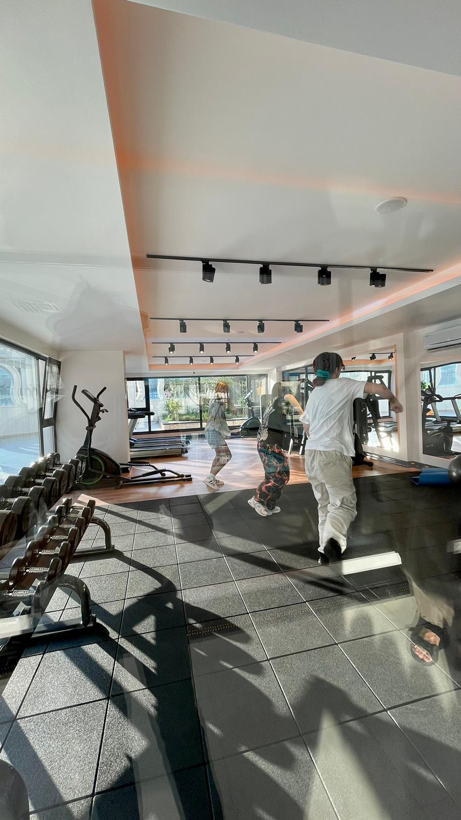 Aynalı spor salonunda dambıl ve koşu bantları, Mahmutlar’daki yaşam alanında