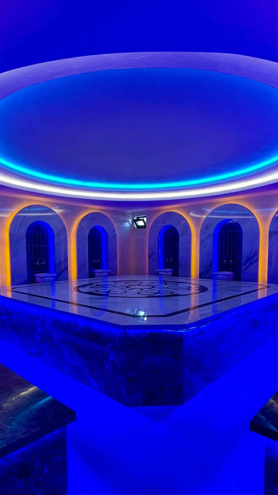 Mermer platformlu hamam, Mahmutlar’daki rezidansta kemerli nişler ve mavi aydınlatmayla