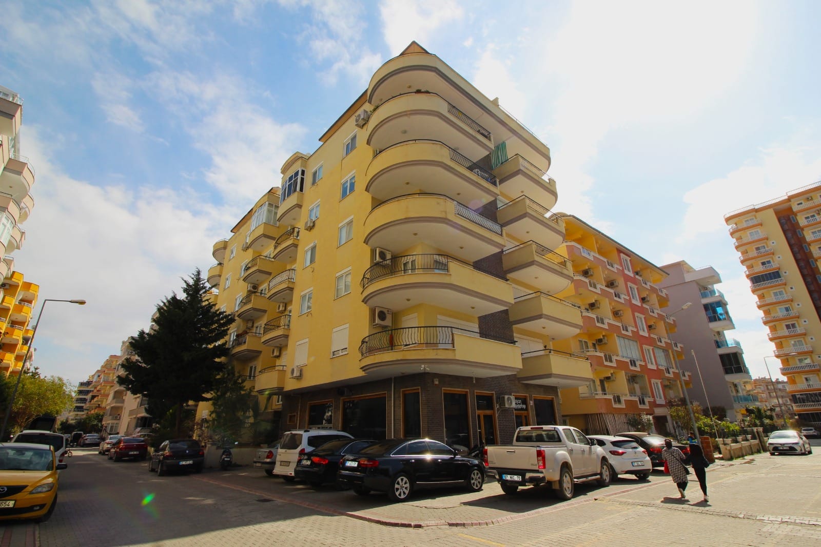 Panoramik pencereli sarı apartman cephesi: Mahmutlar’da satılık 2+1 daire, Türkiye — New Level Group
