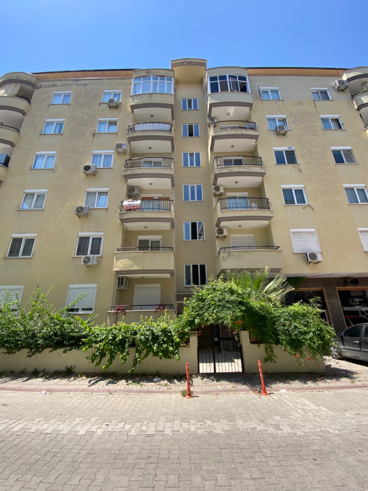 Camlı cumbaları ve beyaz pencere çerçeveleriyle bej cepheli konut Mahmutlar’da Türkiye’de