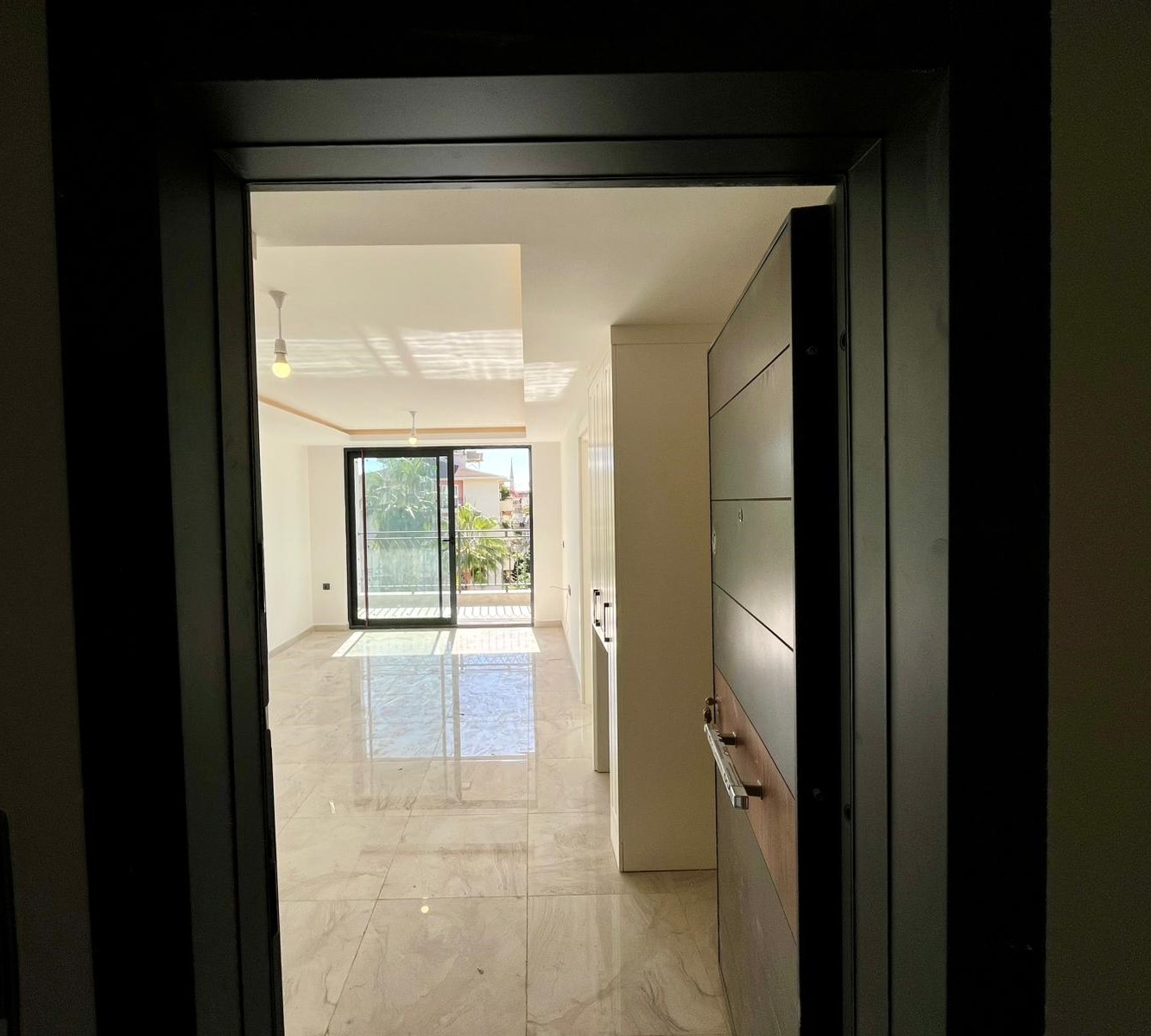 Bright kitchen-living room with marble-effect floor and balcony door in an apartment for sale