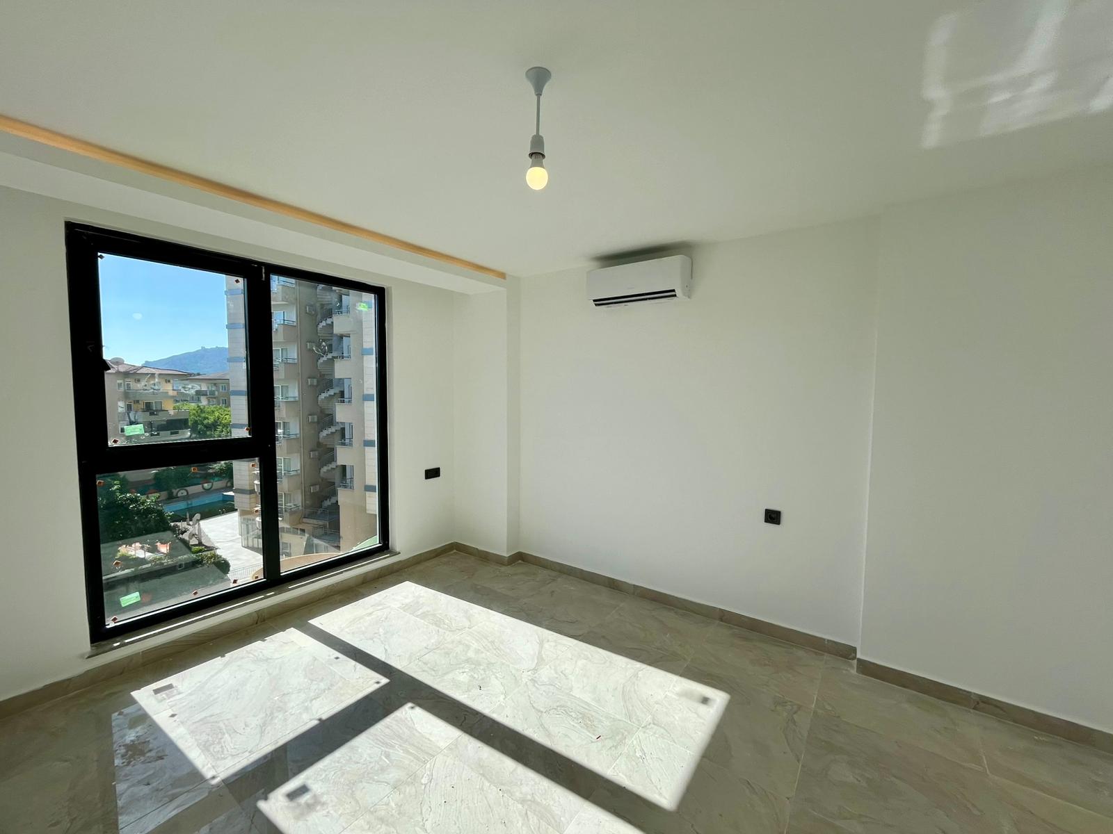 Bedroom with a panoramic black-framed window, marble-effect floor and mountain view