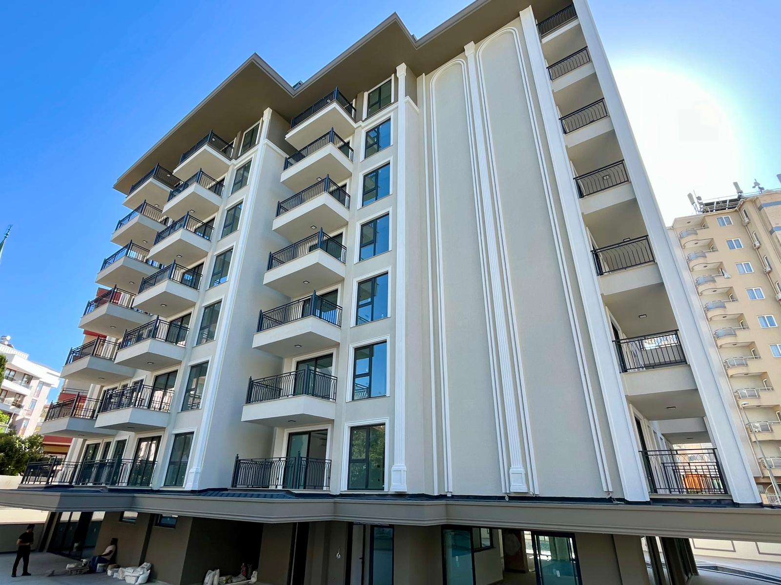 White high-rise facade with open balconies: a 1+1 apartment for sale in Alanya, Turkey — New Level Group