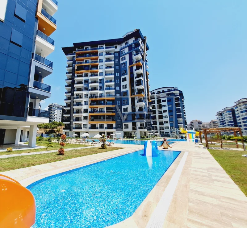 Pool with a water slide at a 1+1 apartment complex for sale in Mahmutlar, Alanya, Turkey — New Level Group