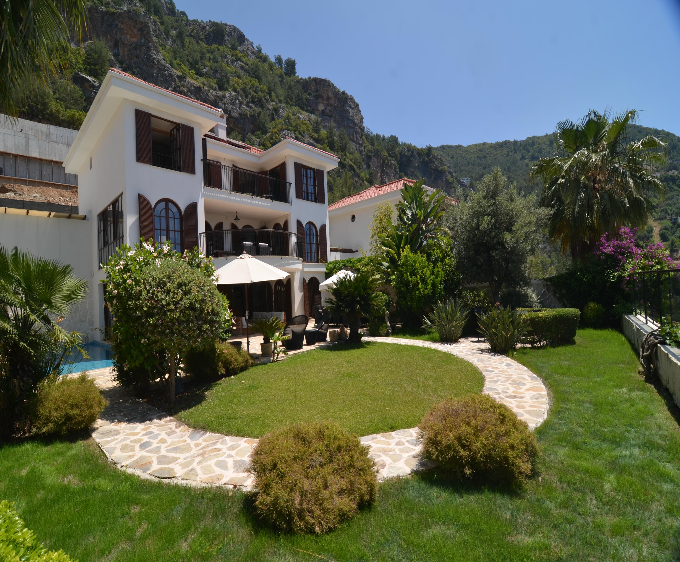 White villa facade with arched windows and red tile roof: a 5+2 villa for sale in Alanya, Turkey — New Level Group