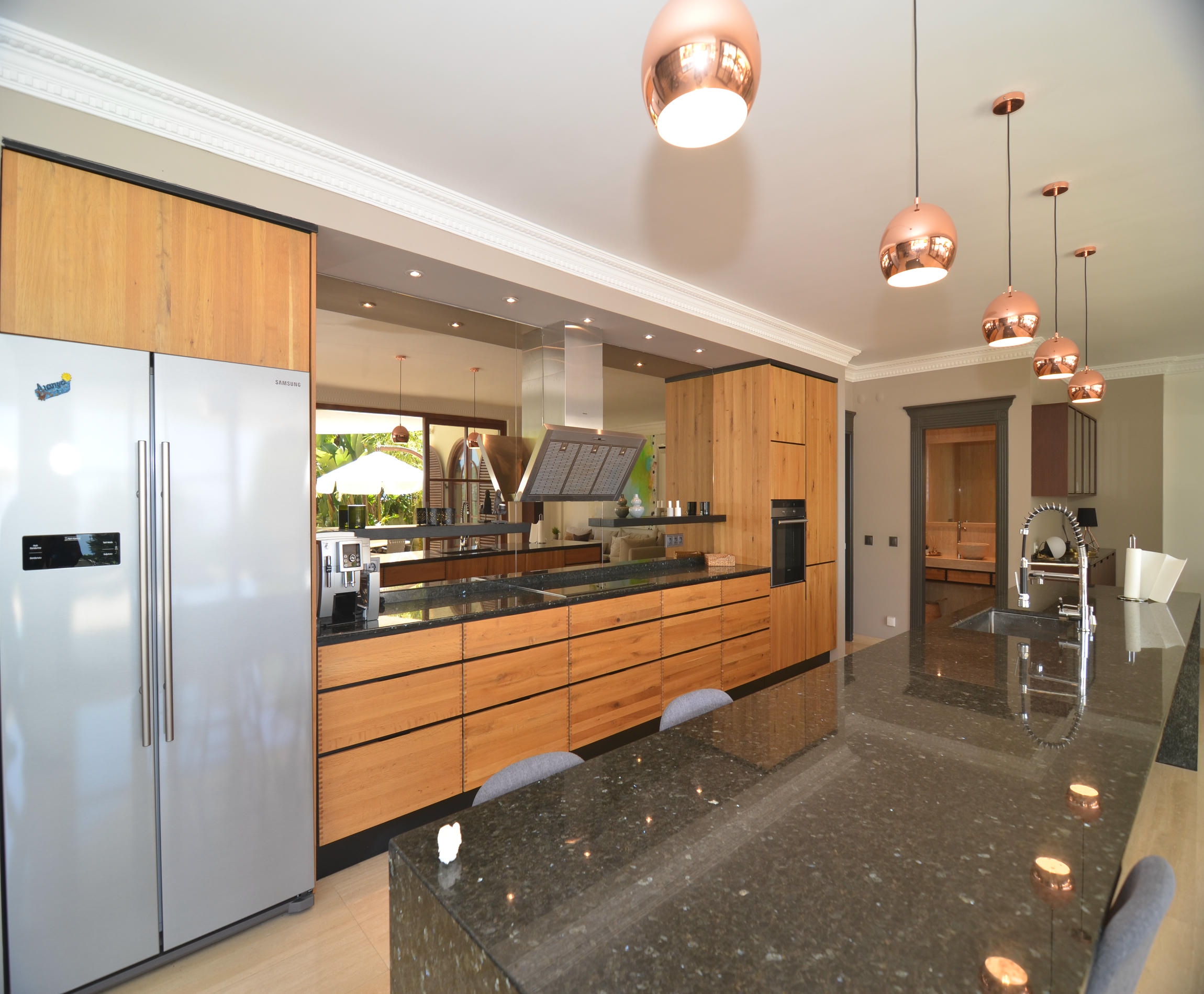 Kitchen with a black stone island and double-door refrigerator in an Alanya villa