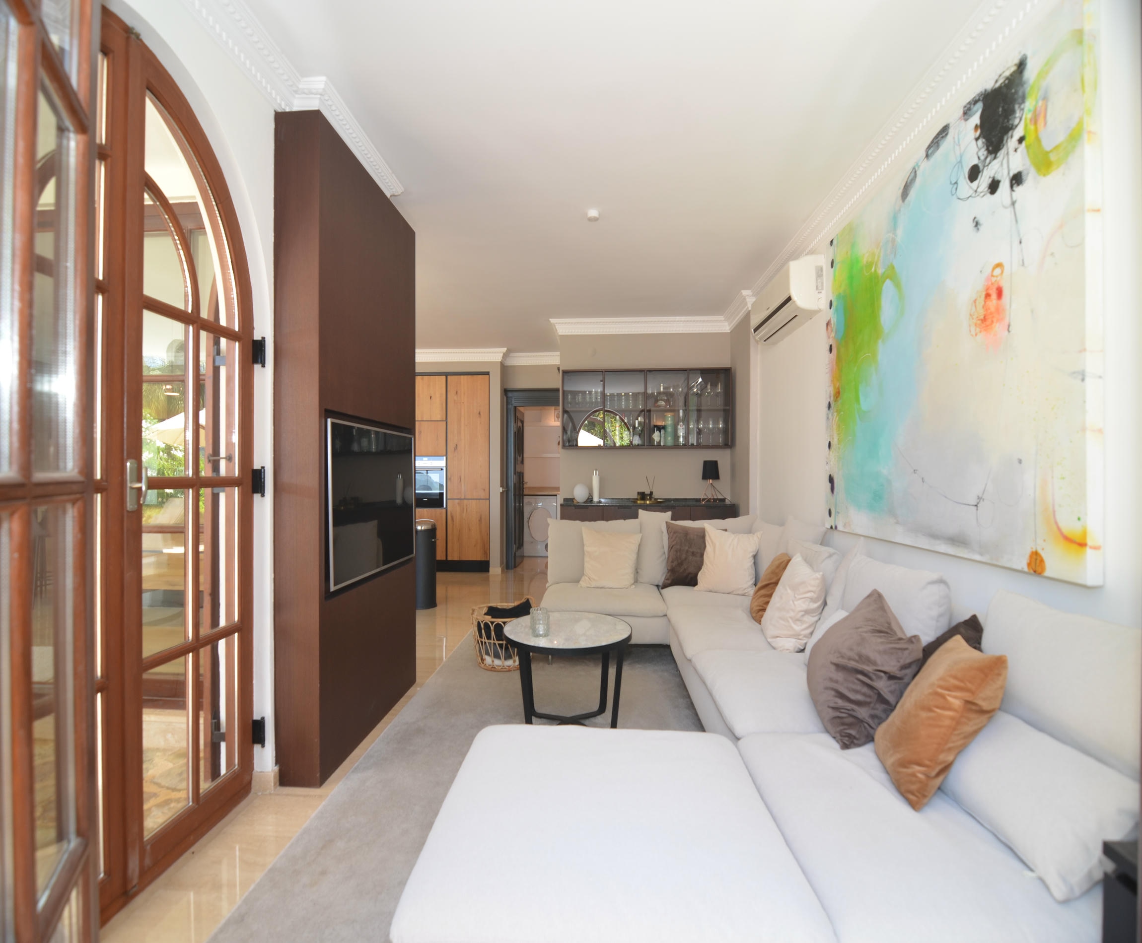 Living room with a white corner sofa and arched wooden door in Alanya where homes are for sale