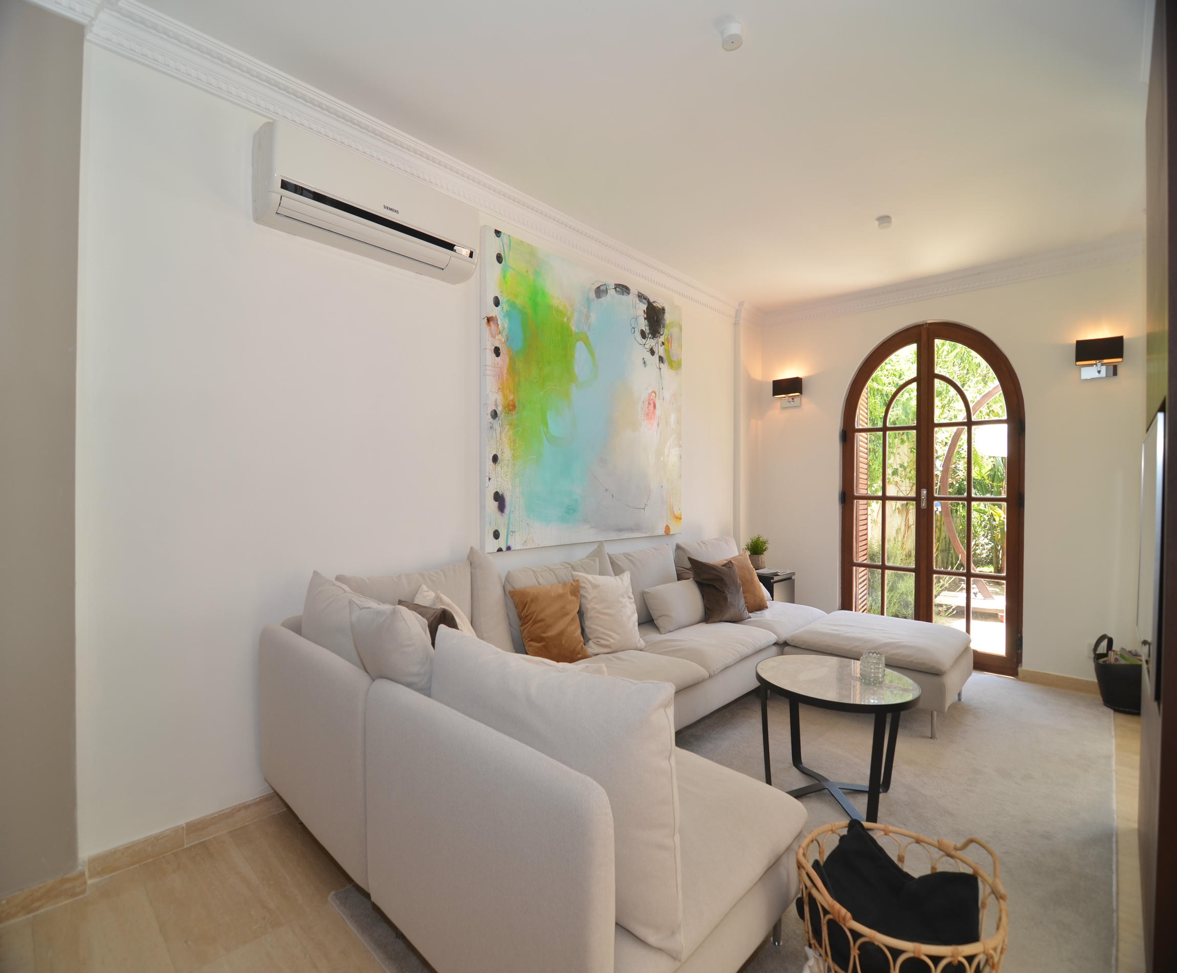 Living room with a white corner sofa, rug and arched window in an Alanya villa in Turkey