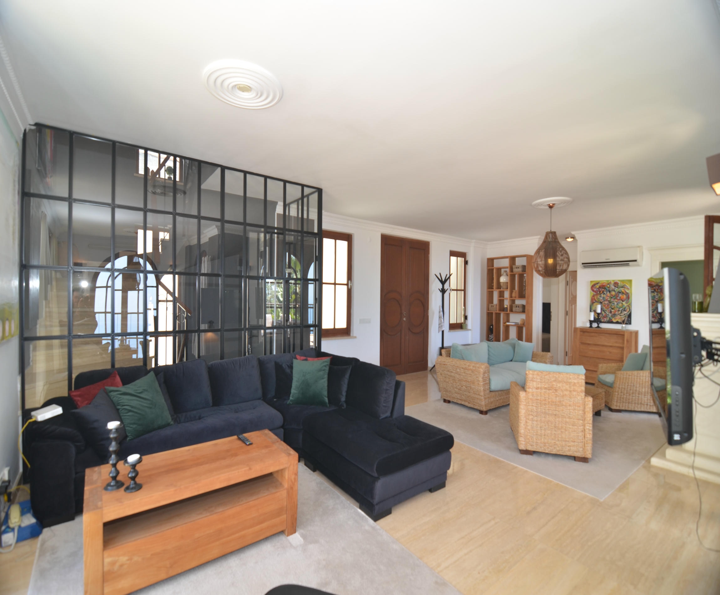 Living room with a dark blue corner sofa and glazed partition in a home for sale