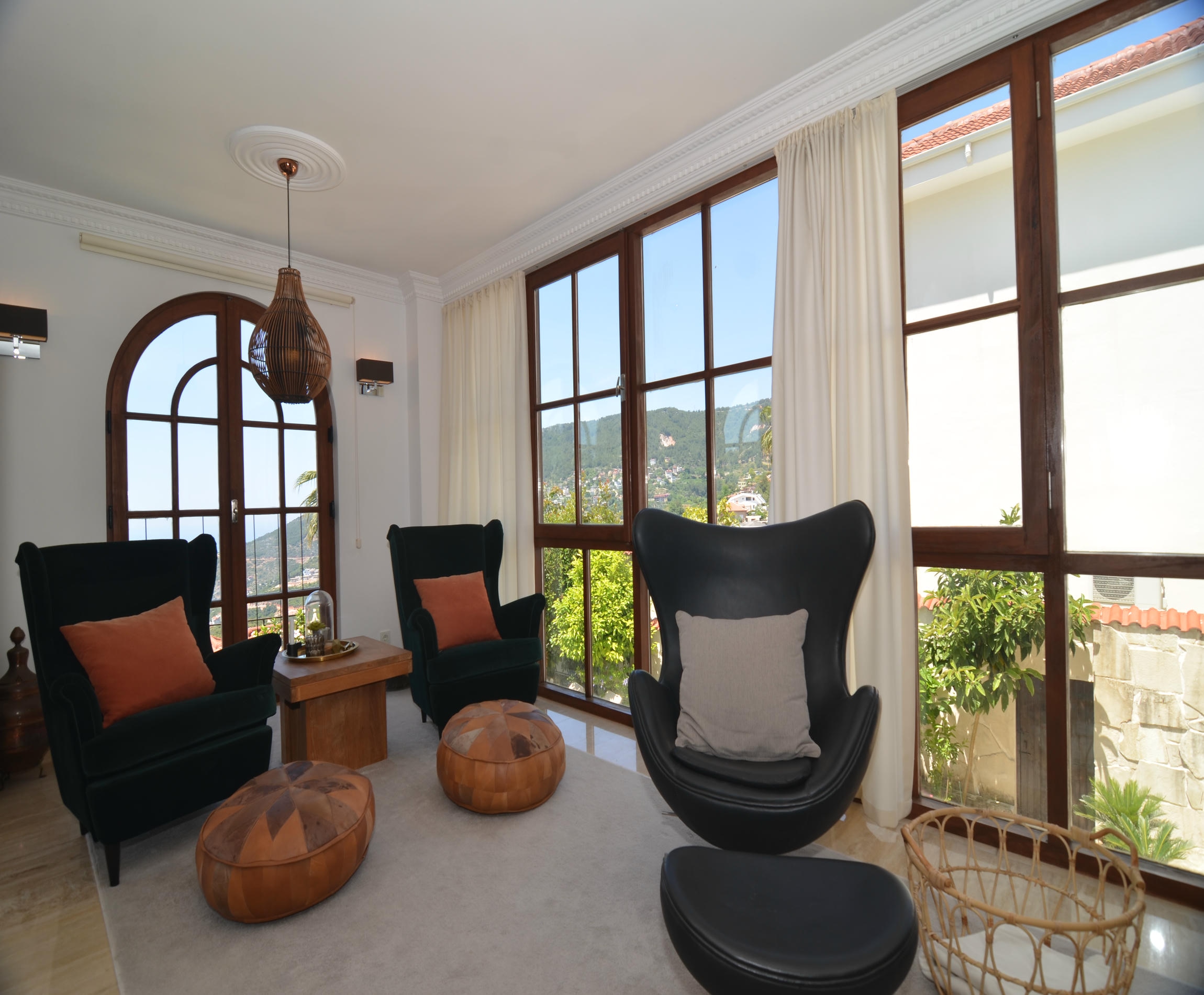 Living room with three black chairs and panoramic windows in a villa for sale