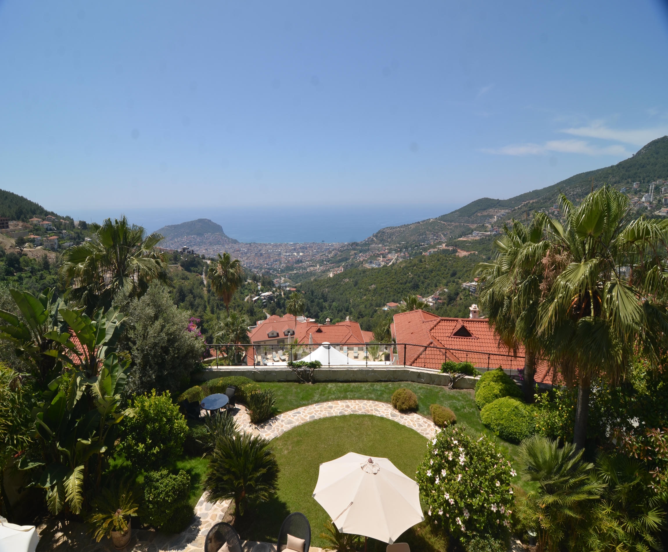 Panoramic sea view over a mountain slope and palm garden from a villa for sale