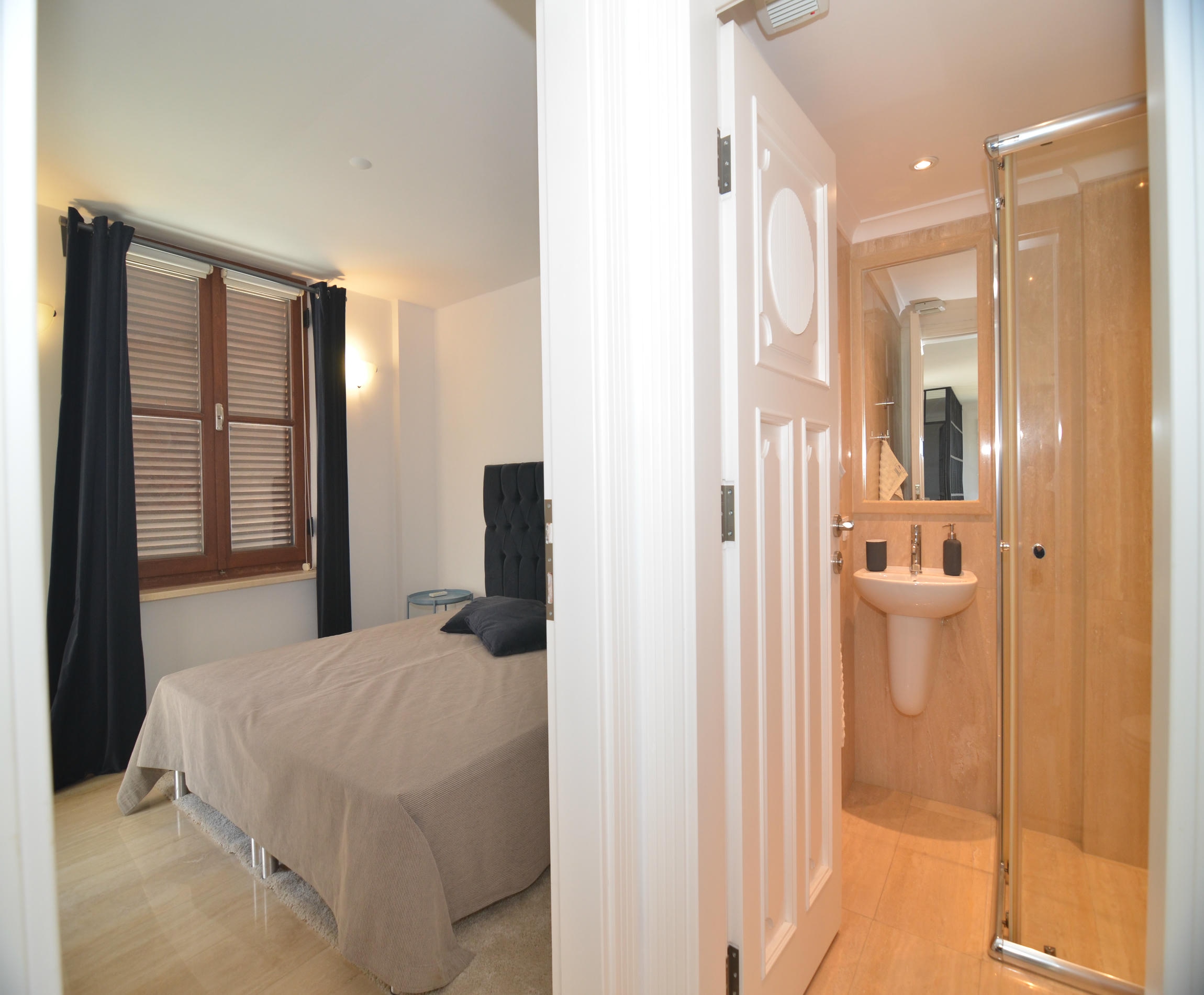 Bedroom with a double bed and glass shower cabin through the adjoining door in an Alanya villa