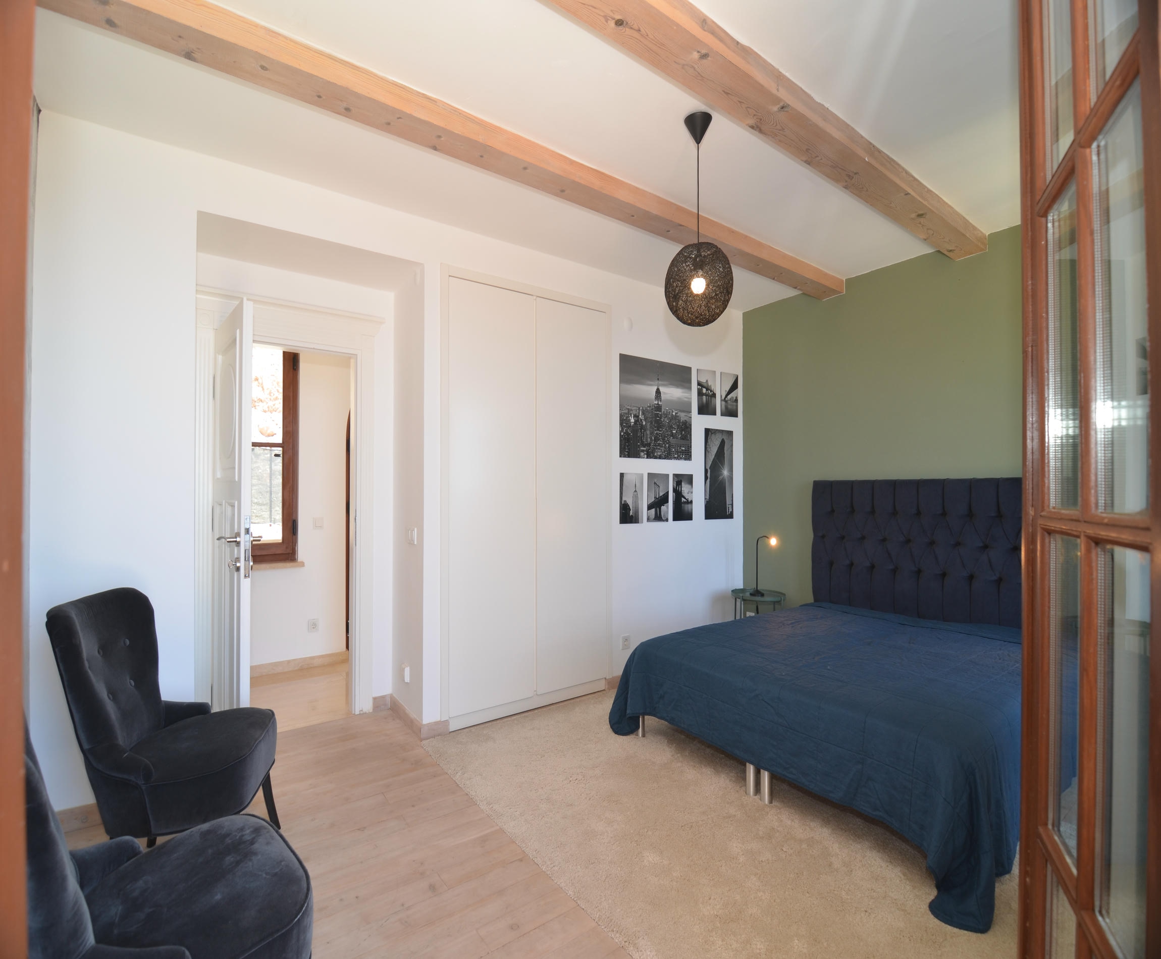Bedroom with a dark blue bed, built-in wardrobe and armchair in Alanya